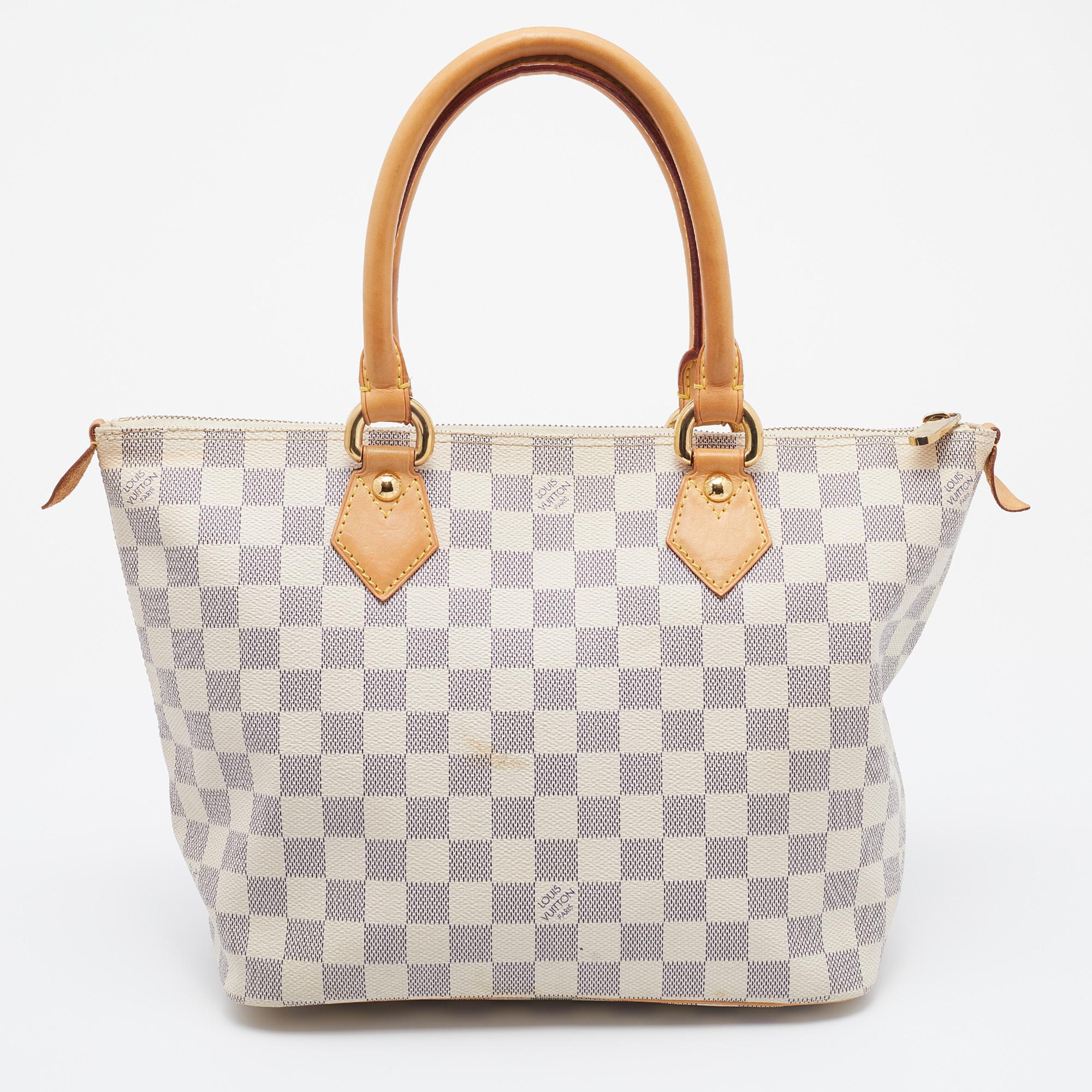 With an architectural shape, this Louis Vuitton Saleya PM bag is impressive with its minimal design and classic elements. It is made from Damier Azur canvas and reminds you of the label's meticulous craftsmanship. Lined with Alcantara, it is capable