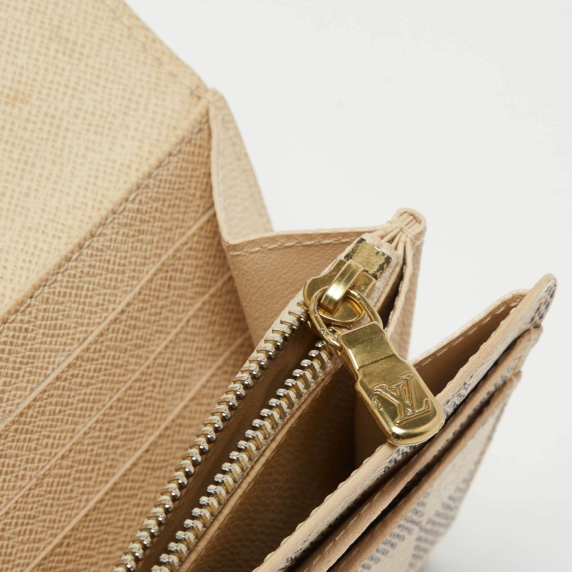 Crafted from the Damier Azur canvas  this Louis Vuitton Sarah wallet is a valuable accessory. Its compartmentalized interior is perfect to store your monetary essentials  and the gold tone accents add to the charm of the wallet.