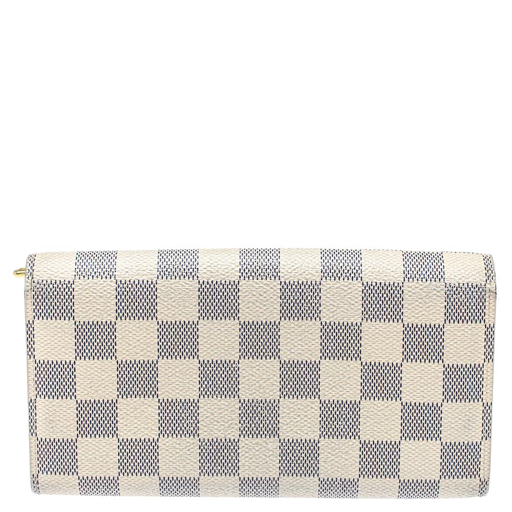One of the most famous wallets by Louis Vuitton is the Sarah. This one here comes made from Damier Azur coated canvas and the button on the flap opens to an interior with multiple card slots and a zip pocket. Perfect in size, this wallet can easily
