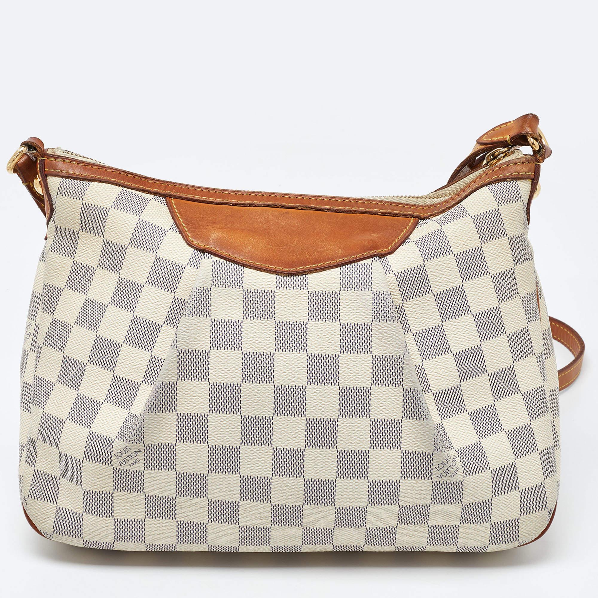 Like every other Louis Vuitton creation, this Siracusa bag also promises high quality and a timeless style. Crafted from signature Damier Azur canvas, the bag is fixed with a leather shoulder strap. The canvas-lined interior is sized to hold your