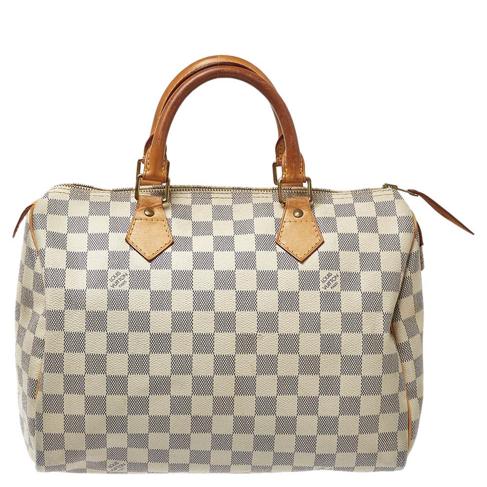 Fashioned from the signature Damier Azur canvas, the Speedy by Louis Vuitton is an elegant, compact handbag, a stylish companion for city life. Launched in 1930 as the 'Express' and inspired by that era's rapid transit and a smaller interpretation