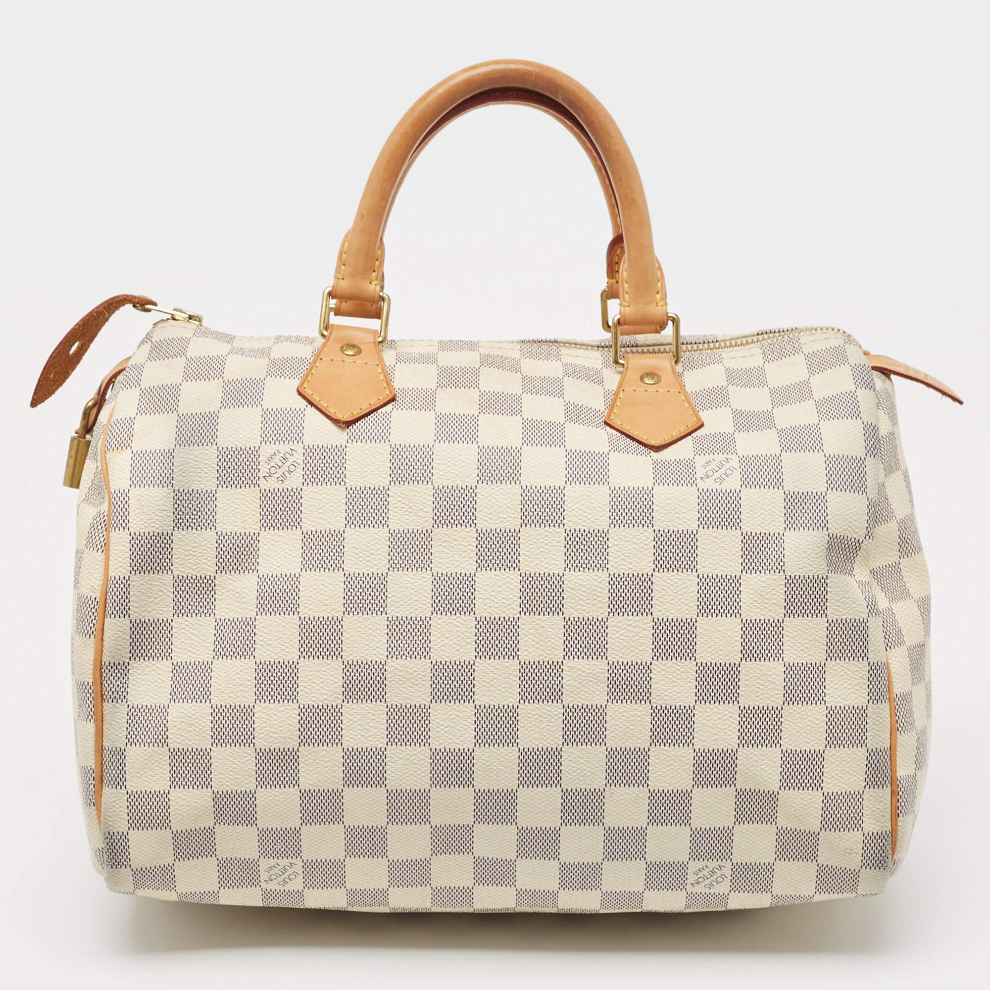 Created to provide you with everyday ease, this Louis Vuitton Speedy 30 bag features dual top handles and a roomy fabric-lined interior. The usage of the signature Damier Azur canvas in its construction offers instant brand identification. Gold-tone