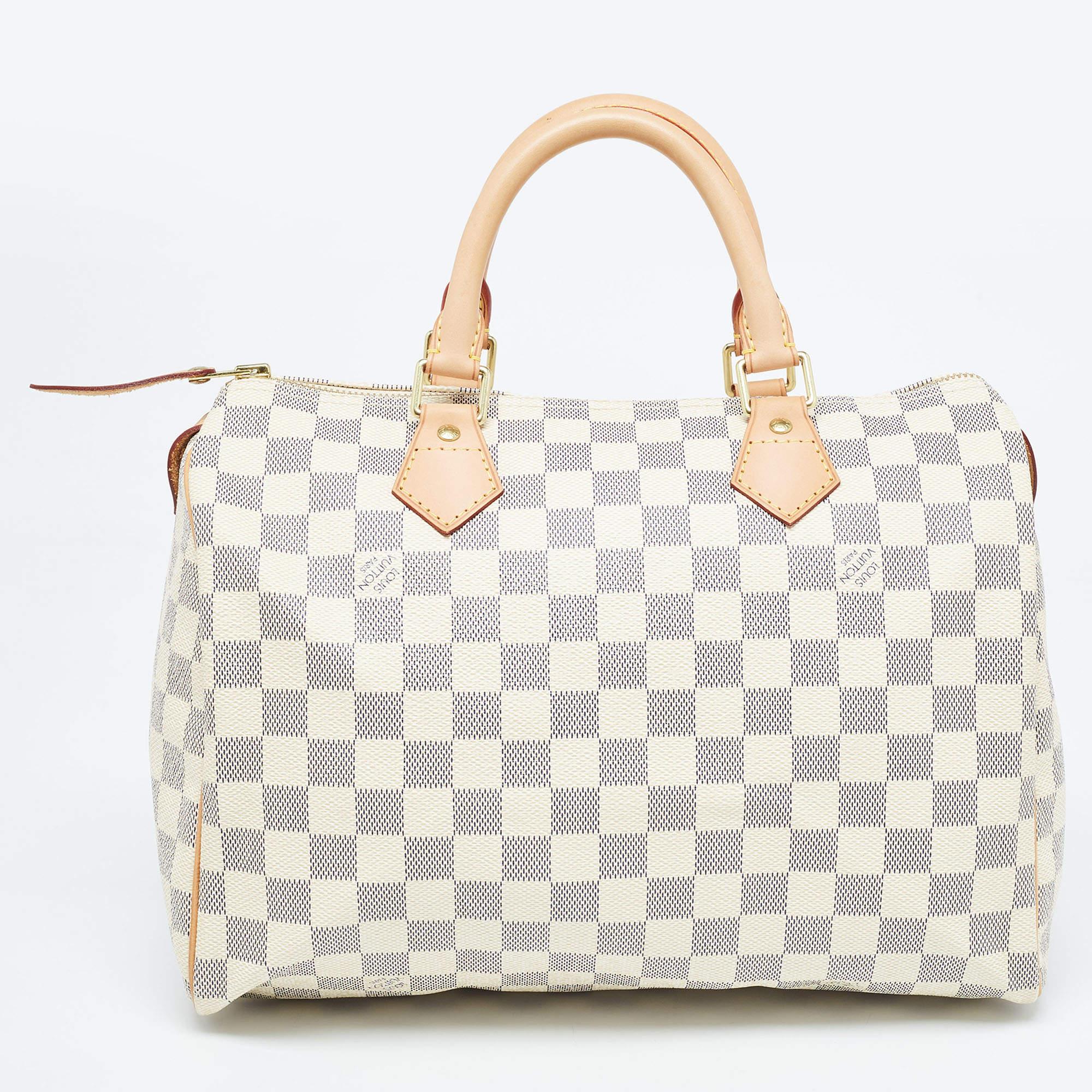 Created to provide you with everyday ease, this Louis Vuitton Speedy 30 bag features dual top handles and a roomy canvas-lined interior. The usage of the signature Damier Azur canvas in its construction offers instant brand identification. Gold-tone