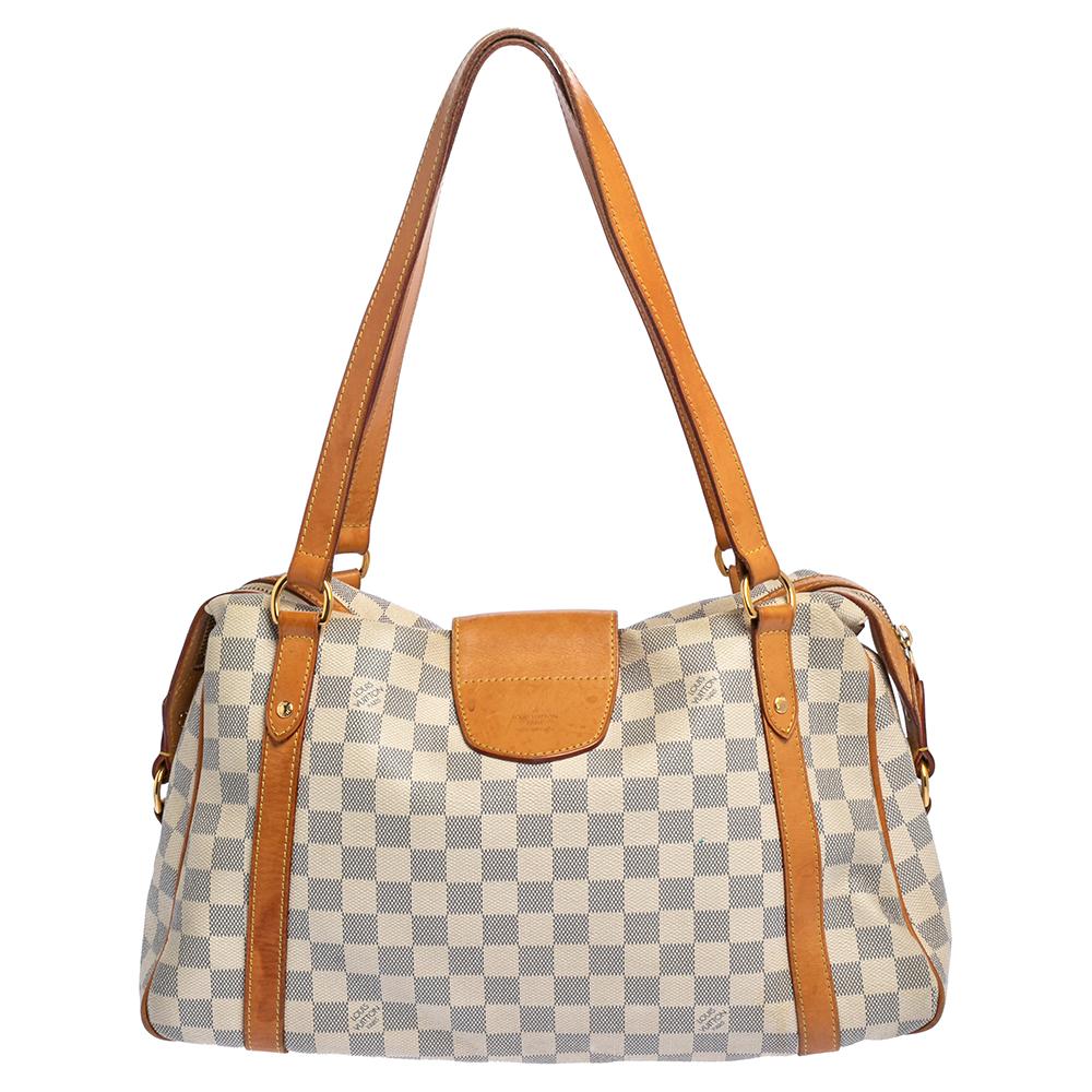 This Stresa PM by Louis Vuitton will add ease to your daily routine. Crafted from Damier Azur canvas with tan leather trims, it features a top zipper closure, dual handles, and polished gold-tone hardware. The canvas-lined interior has ample space