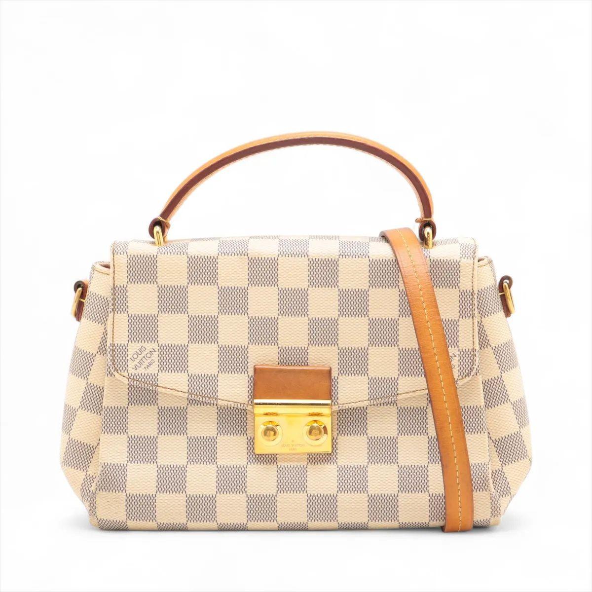 Le sac à main Louis Vuitton Damier Azur Croisette est un sac à main compact et élégant qui respire le charme féminin et la polyvalence. Confectionné en toile enduite Damier Azur, fraîche et élégante, il est orné d'une garniture en cuir de vachette