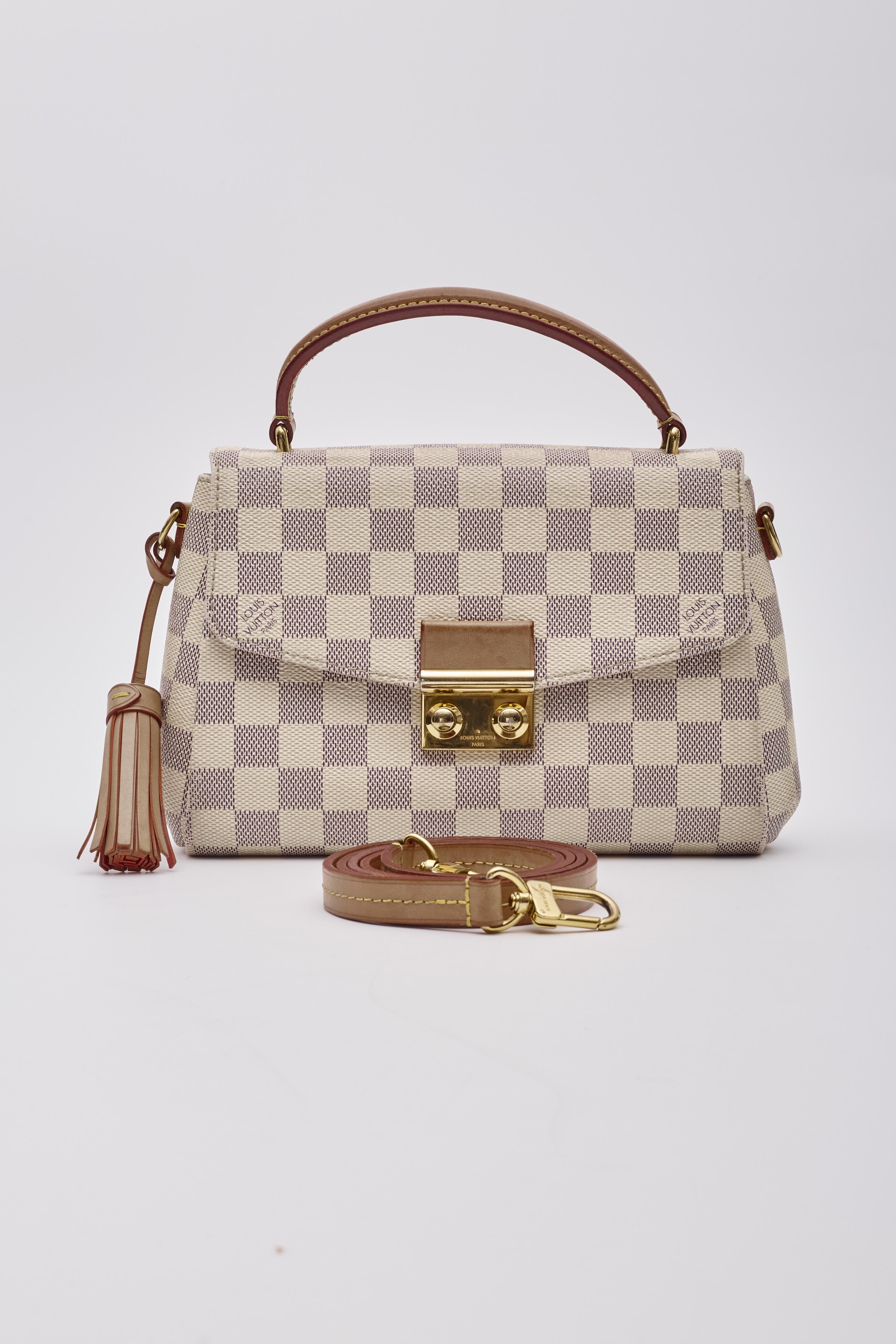 This compact bag is made of Louis Vuitton coated canvas in Damier azur. The bag features signature vachetta cowhide leather trim including a top handle with a removable tassel, and an optional shoulder strap with brass hardware. The crossover flap
