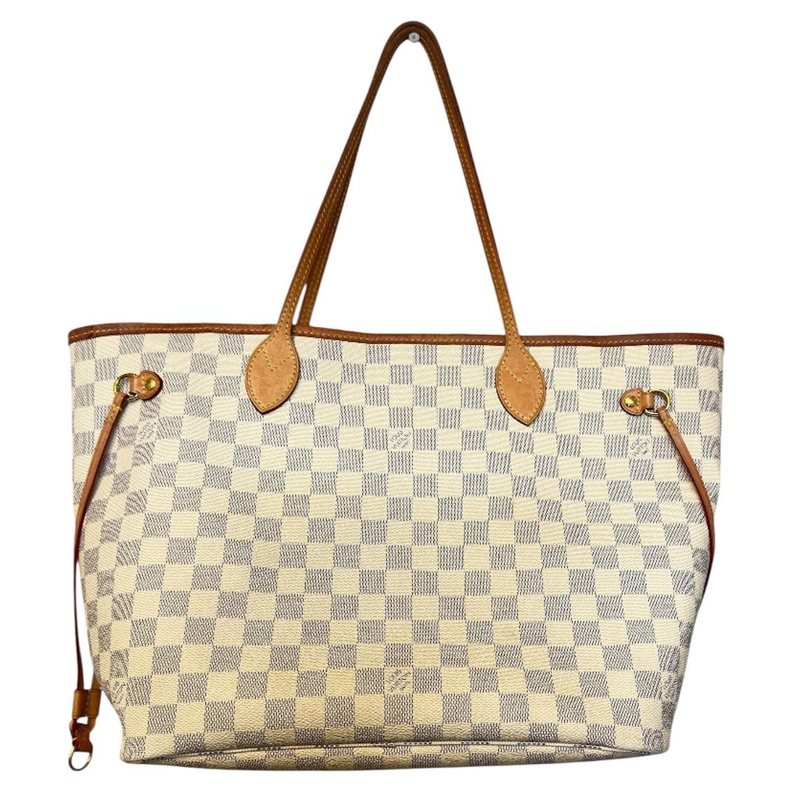 Eleva il tuo stile quotidiano con questa autentica Neverfull MM Tote di Louis Vuitton in elegante tela Damier Azur. Questa iconica tote presenta finiture in pelle di vacchetta naturale, finiture in oro lucido e un interno spazioso e versatile con