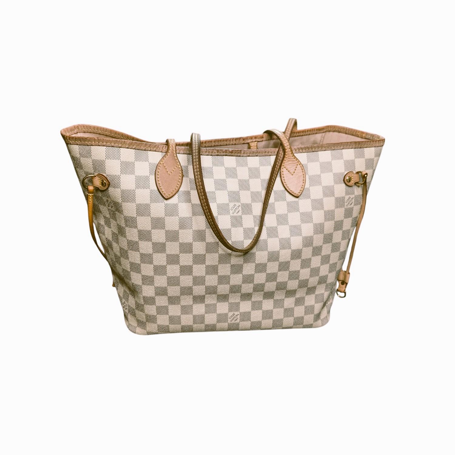 This tote is crafted of Louis Vuitton's signature Damier canvas in blue and white. This shoulder bag features vachetta cowhide leather trim including strap handles and side cinch-cords with polished brass hardware. The bag opens to a pink striped