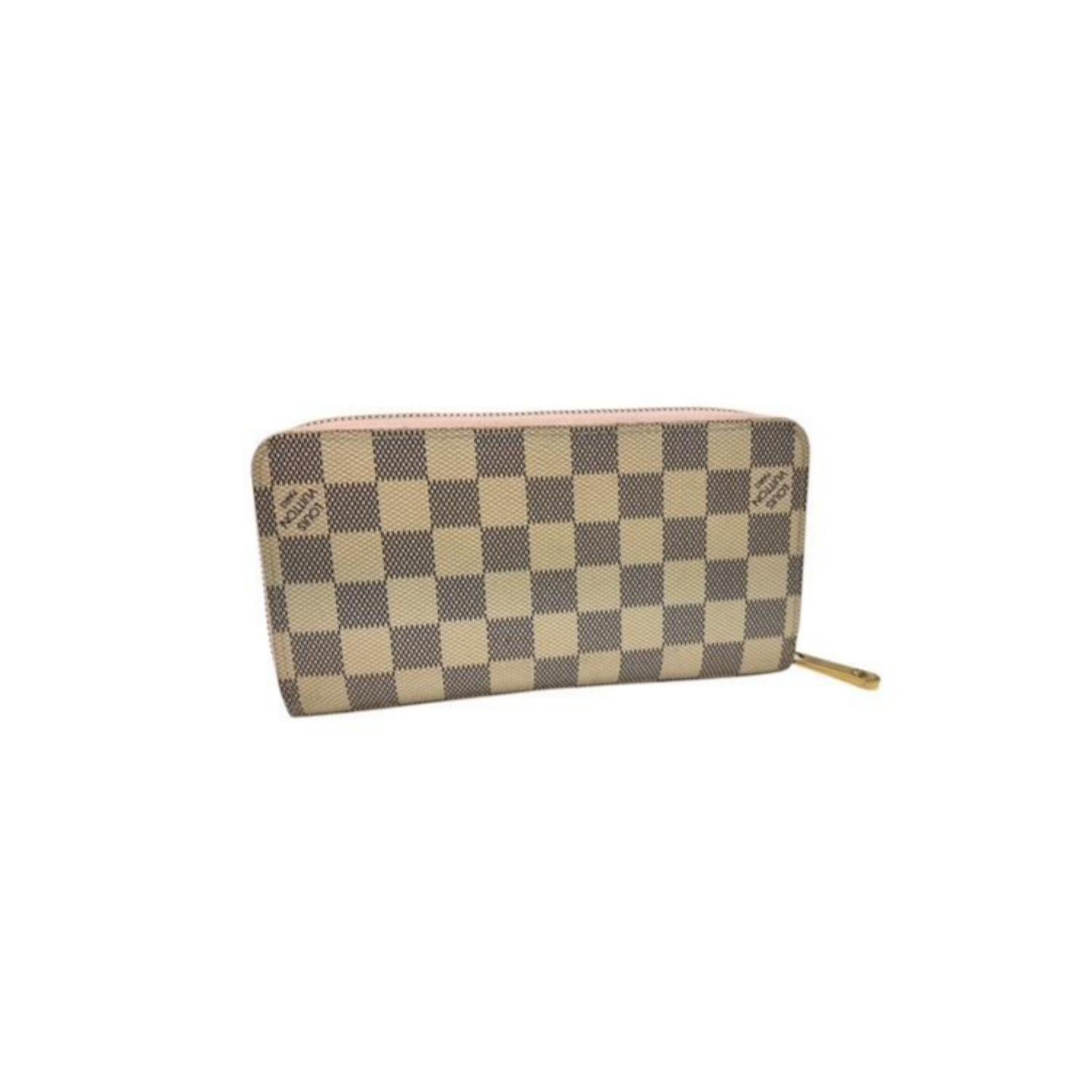 This Louis Vuitton Zippy Wallet in Damier Azur canvas features a secure wrap-around zipper and a Rose Ballerine pink leather interior. It offers 12 card slots, 4 slip pockets, and a central zippered coin compartment for organized storage. Combining