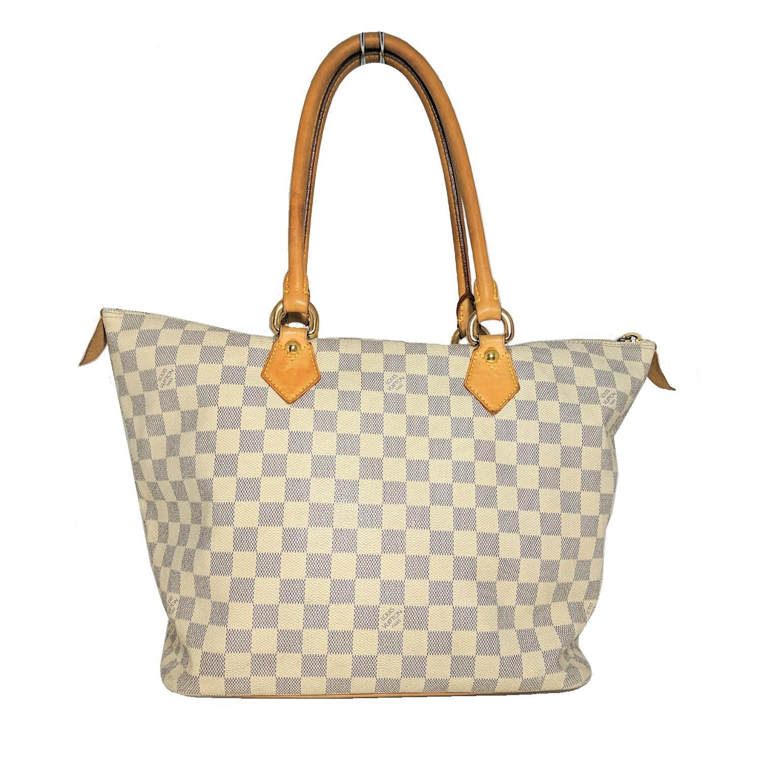 Creme and navy Damier Azur coated canvas Louis Vuitton Azur Saleya MM tote with brass hardware, dual rolled shoulder straps, tan Vachetta leather trim, beige Alcantara lining, dual slit pockets at interior wall and zip closure at top. Retail