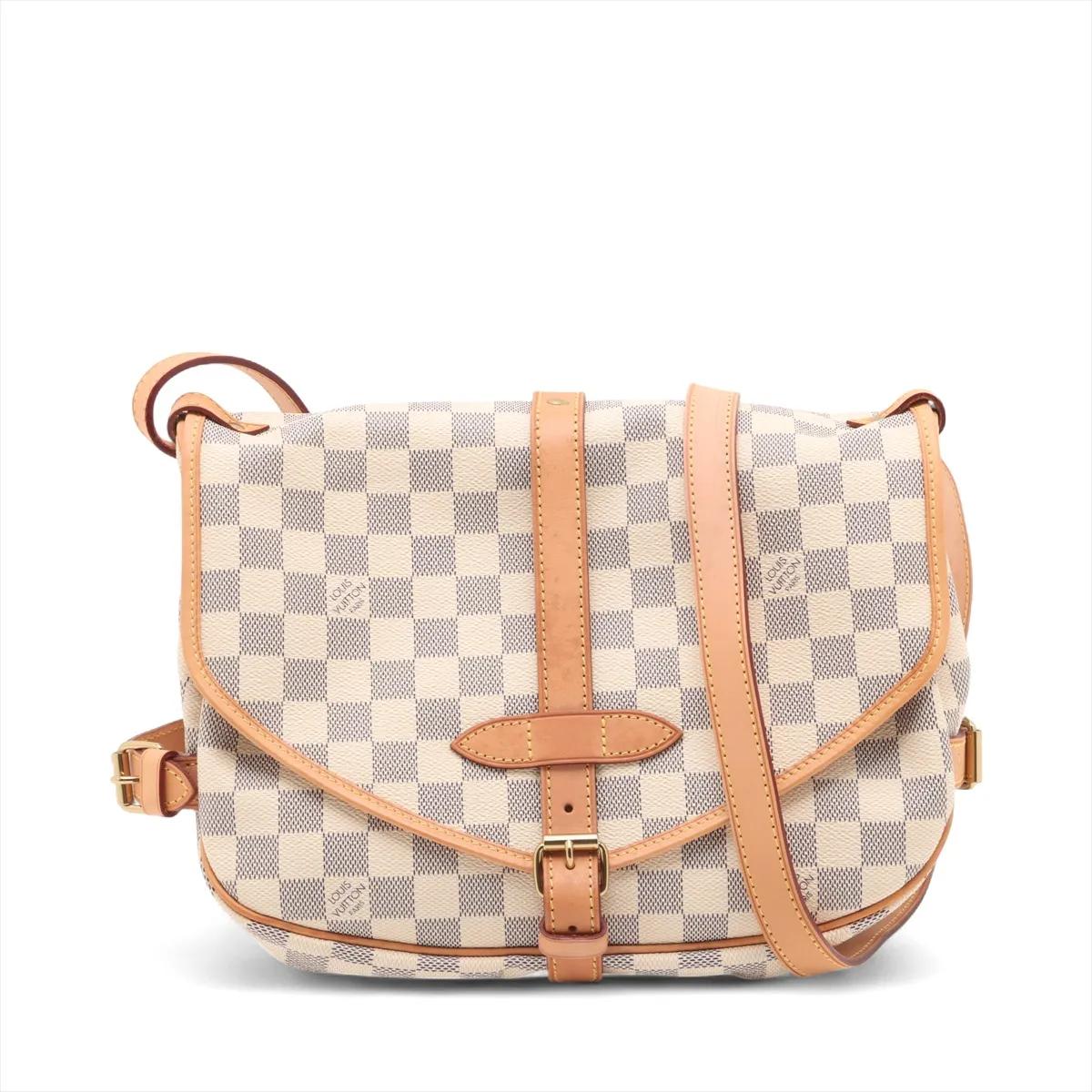 Le sac Louis Vuitton Damier Azur Saumur 30 est un sac à bandoulière classique et polyvalent qui allie un design intemporel à une fonctionnalité pratique. Confectionné en toile Damier Eleg et garni de cuir de vachette naturel, il présente une