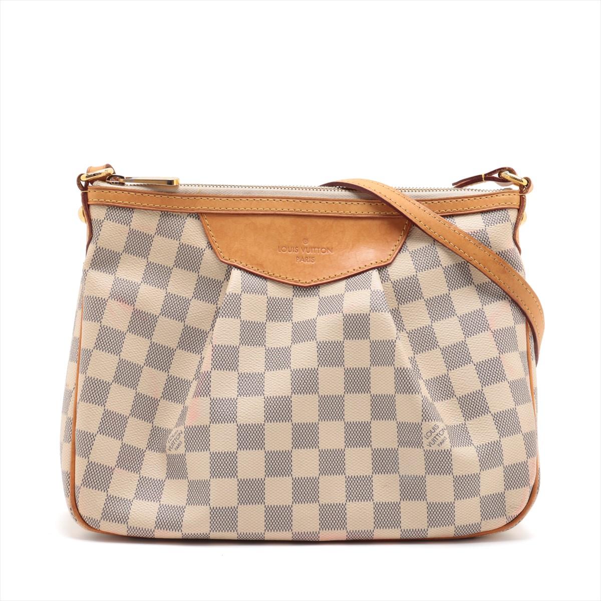 The Louis Vuitton Damier Azur Siracusa PM is a chic and practical handbag that effortlessly combines style with everyday functionality. Crafted from the iconic Damier Azur canvas, the bag features a fresh and summery color palette with a distinctive