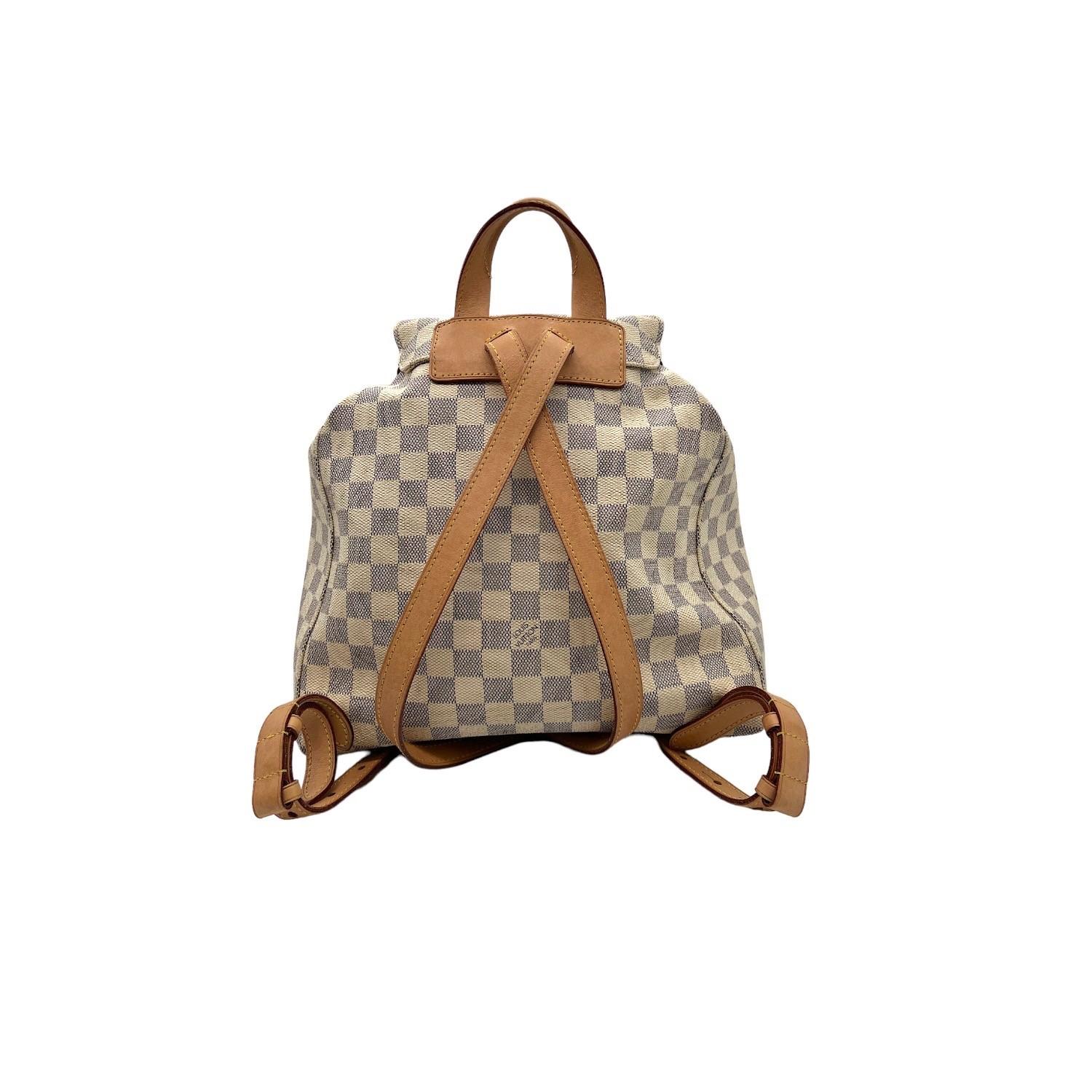 This very beautiful Louis Vuitton backpack is finely crafted of Damier Azur coated canvas with leather trimming and gold-tone hardware features. It has dual adjustable leather shoulder straps along with a small leather handle on the top. It has a