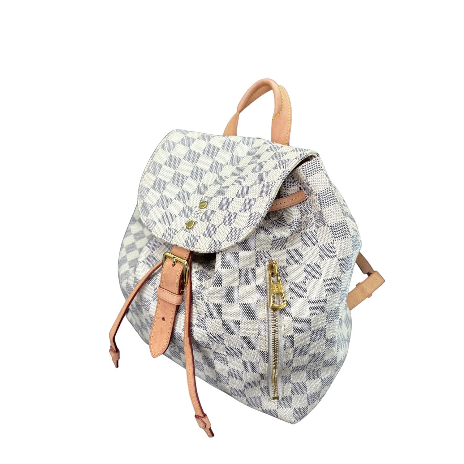 This Louis Vuitton backpack was made in France in 2020 and it is finely crafted in white Louis Vuitton Damier Azur coated canvas with leather trimming and gold-tone hardware features. It has dual adjustable leather shoulder straps along with a small