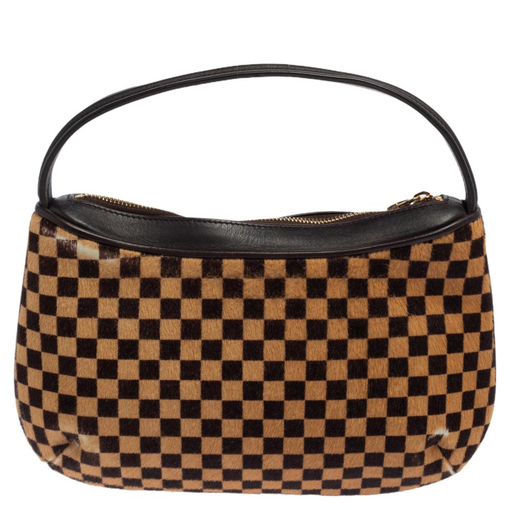 Louis Vuitton's bags are popular owing to their high style and functionality. This limited edition Sauvage Tigre, like all the other bags, is durable and stylish. Beautifully crafted from calf hair in their signature Damier pattern, the bag comes