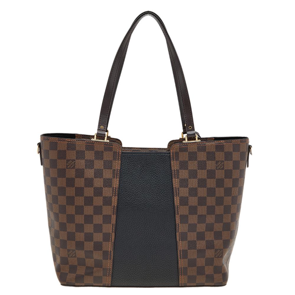 The employment of the signature Damier canvas in its construction gives this Louis Vuitton tote a luxe update. It features a brand-detailed Taurillon leather panel, shoulder strap, and dual handles. Lined with Alcantara, the interior is secured by a