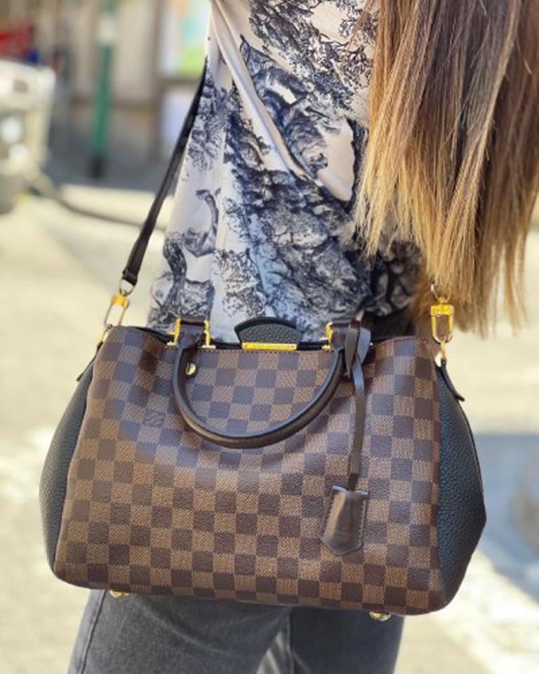 Louis Vuitton bag, Brittany model, made of damier canvas with black leather inserts and golden hardware.

Equipped with a button closure, internally lined in black suede, quite roomy.

Equipped with two rigid brown leather handles, a 1 cm thick
