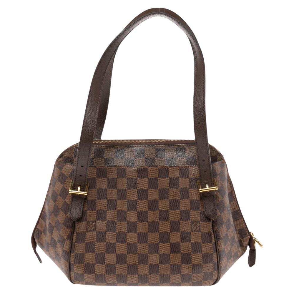 With its unique shape and design, this Louis Vuitton Belem bag will definitely be a showstopper. It features Louis Vuitton's signature Damier Ebene canvas exterior with dark brown leather trim and shoulder straps. It is also accented with gold-tone