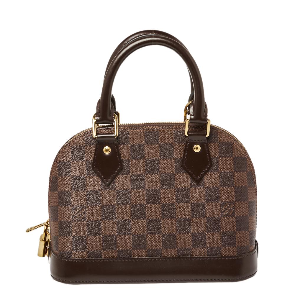 Alma bags are one of the most coveted styles from the house of Louis Vuitton. It was named after the Alma Bridge that connects Paris's fashionable neighborhood. The bag is made from the signature Damier Ebene canvas and features a leather key holder