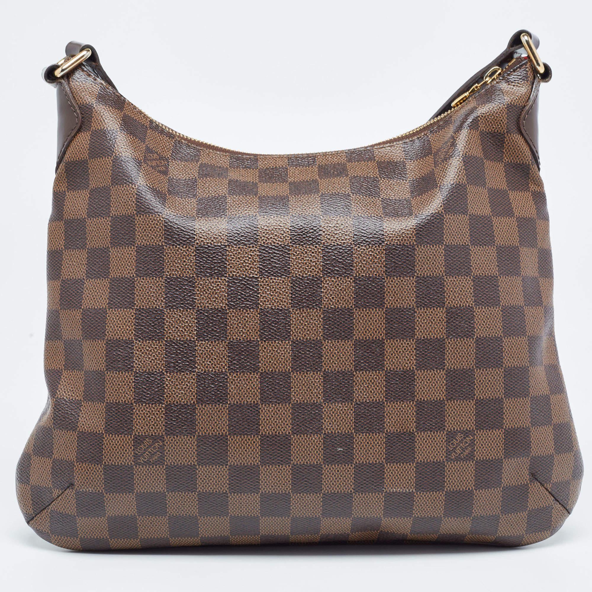 Crafted from Damier Ebene canvas and leather, this Bloomsbury PM from Louis Vuitton is sure to elevate your style. It features a subtle pleat with a Louis Vuitton plaque at the front and a canvas interior secured by a zipper. It is complete with an