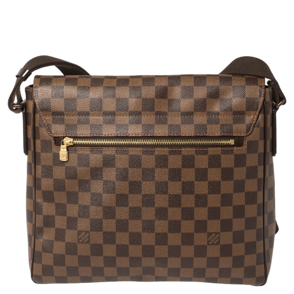 Give a twist to your everyday styling with this District MM bag from Louis Vuitton. Designed in a flap-over style, this bag is fashioned in the signature Damier Ebene canvas and bears the logo plaque on the outer body. It opens to an ultra-spacious