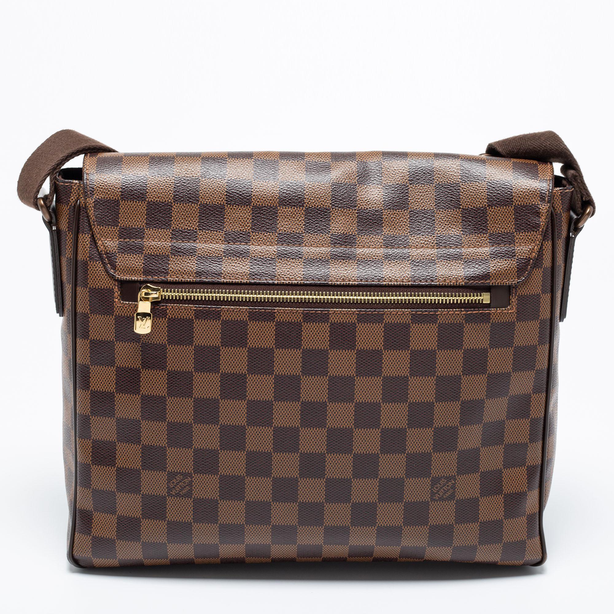 The District MM bag is another utilitarian design from the house of Louis Vuitton. Exuding the label's rich craftsmanship and creativity, the bag is crafted from Damier Ebene canvas into a spacious size. The full flap on the front opens to a