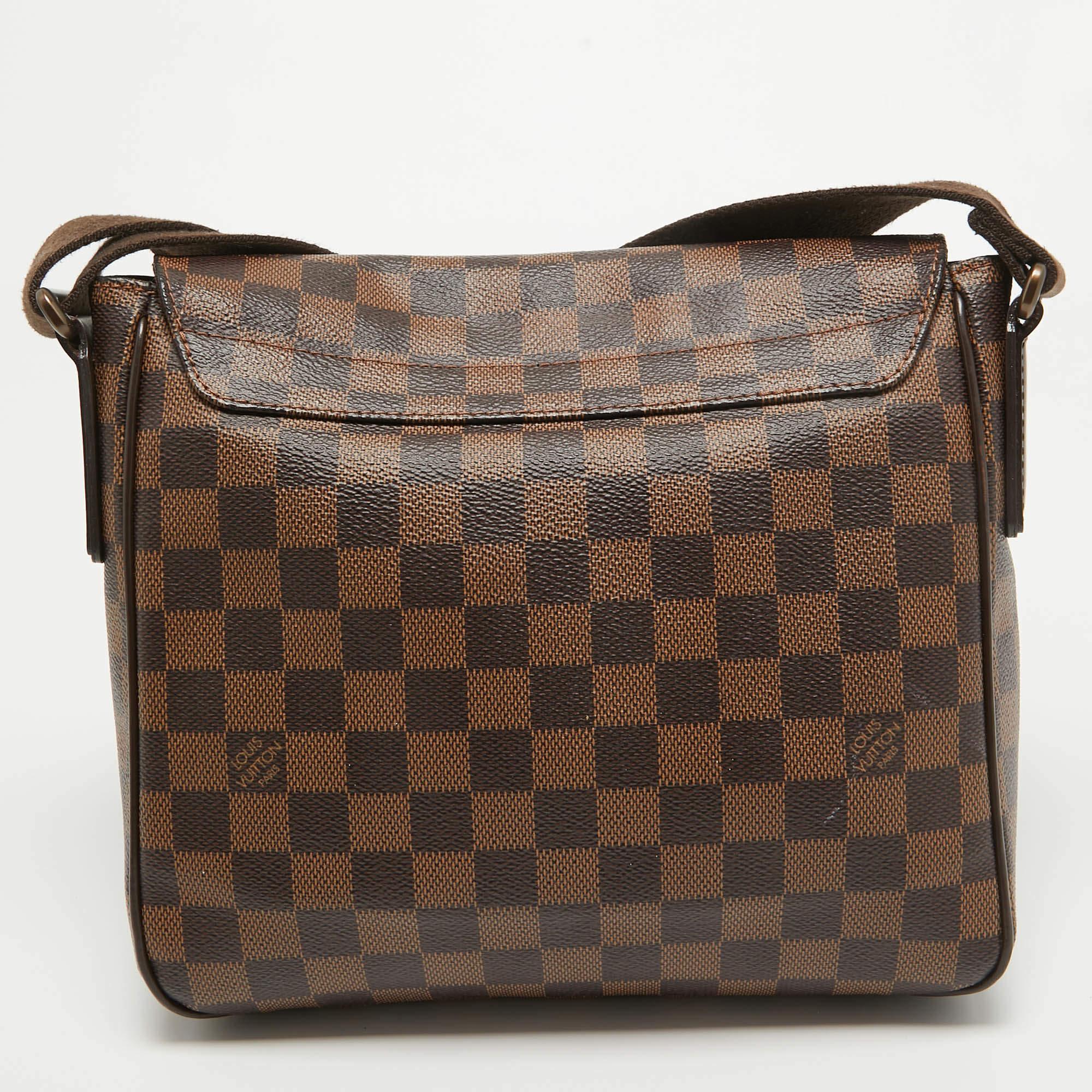 This District PM bag from the House of Louis Vuitton brings you endless style, comfort, and luxury. It is crafted using Damier Ebene canvas and displays brass-tone hardware, a canvas-lined interior, and leather trims. Its shape is complemented with