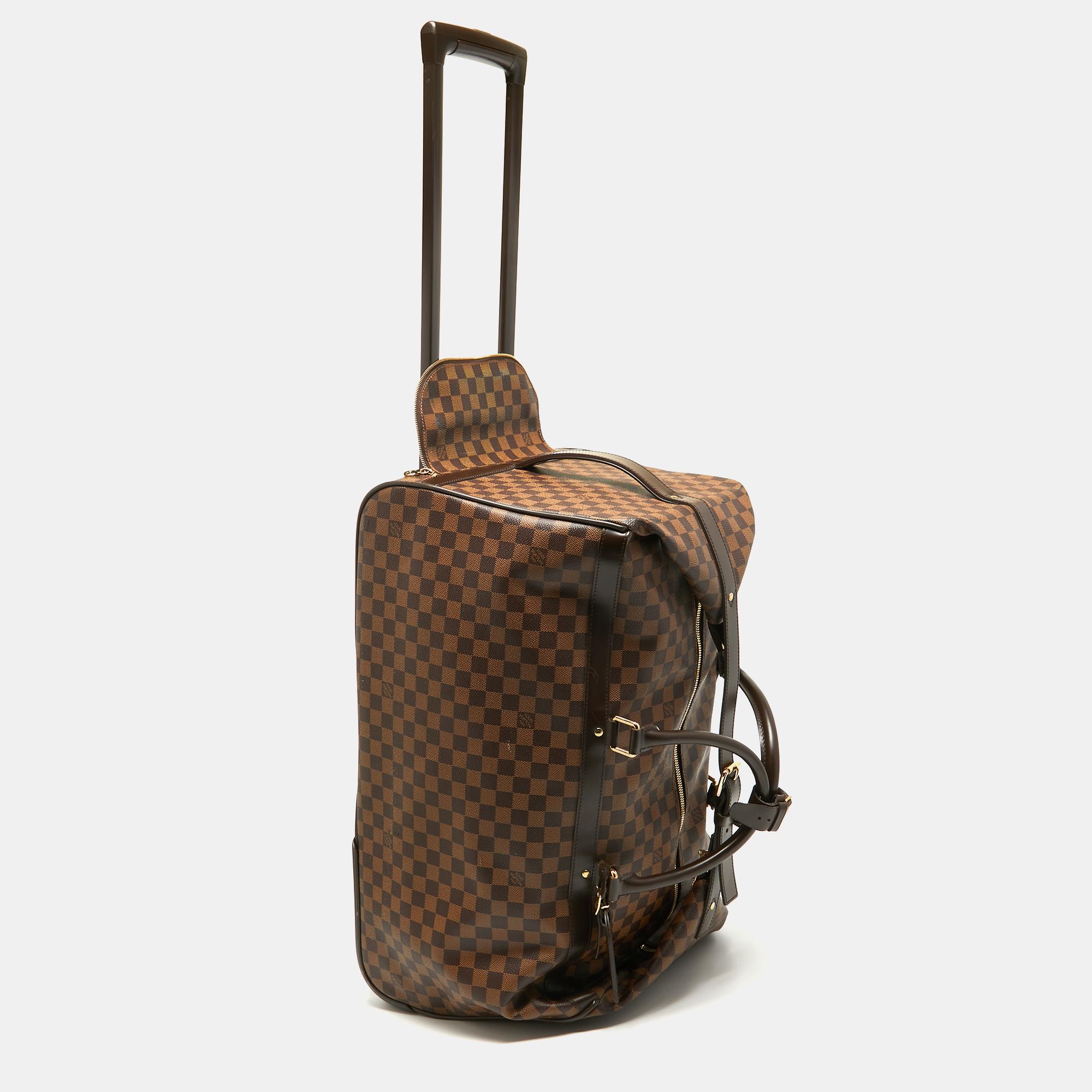 Featuring a chic, yet luxurious style, this Louis Vuitton Eole 60 luggage bag is distinctive. Crafted from signature Damier Ebene canvas and styled with leather, the bag is equipped with dual-rolled handles, trolly wheels, and a concealed handle