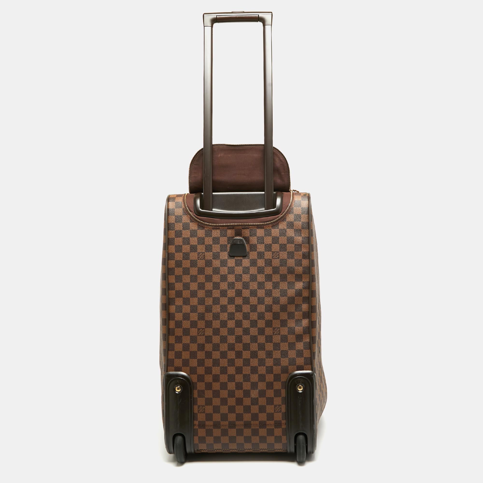 Featuring a chic, yet luxurious style, this Louis Vuitton Eole 60 luggage bag is distinctive. Crafted from signature Damier Ebene canvas and styled with leather, the bag is equipped with dual-rolled handles, trolly wheels, and a concealed handle