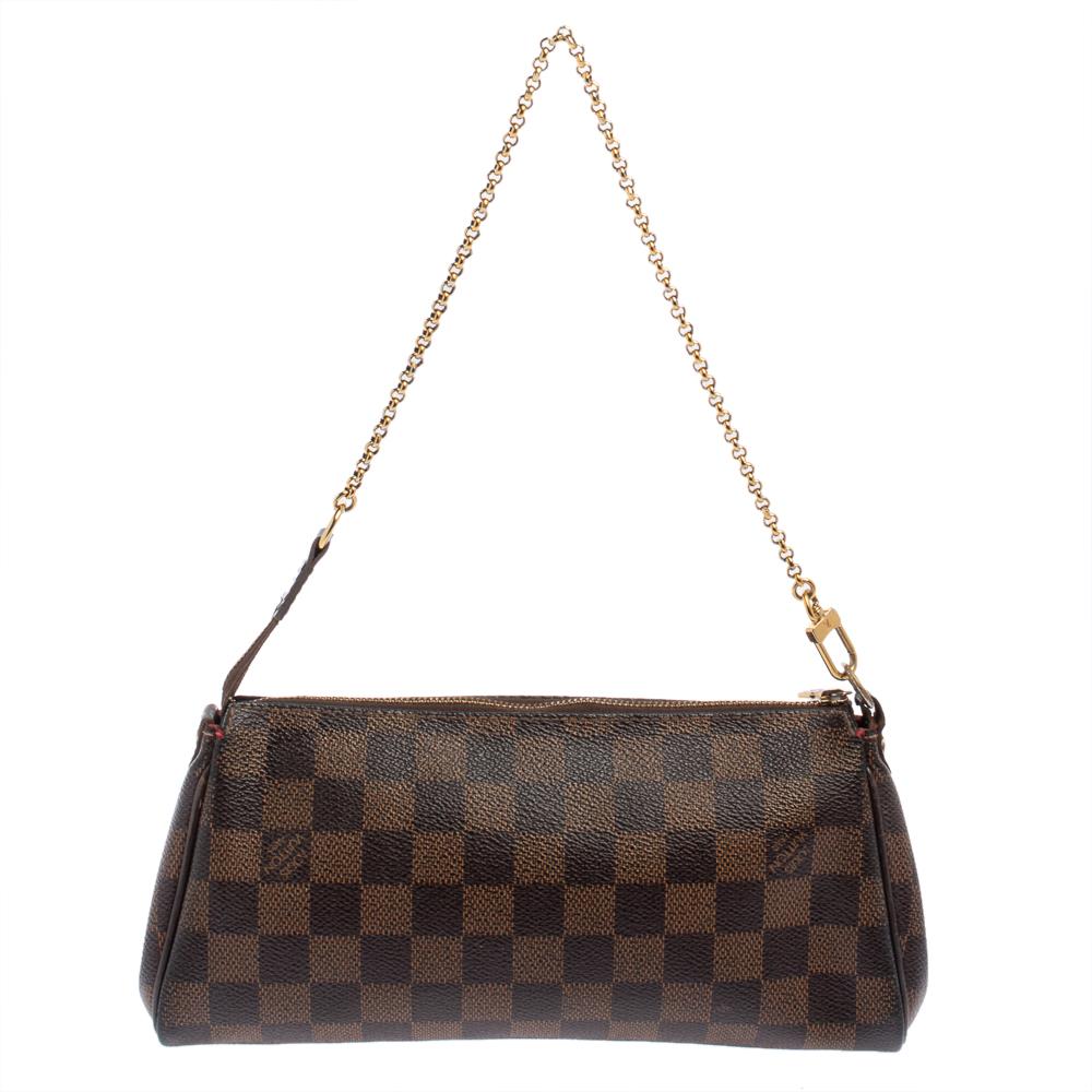 The Eva Pochette bag by Louis Vuitton showcases contemporary charm with its sophisticated shape. Made in France from Damier Ebene canvas, it features a detachable gold-tone chain handle and a top zipper. The metal plate engraved with the label's