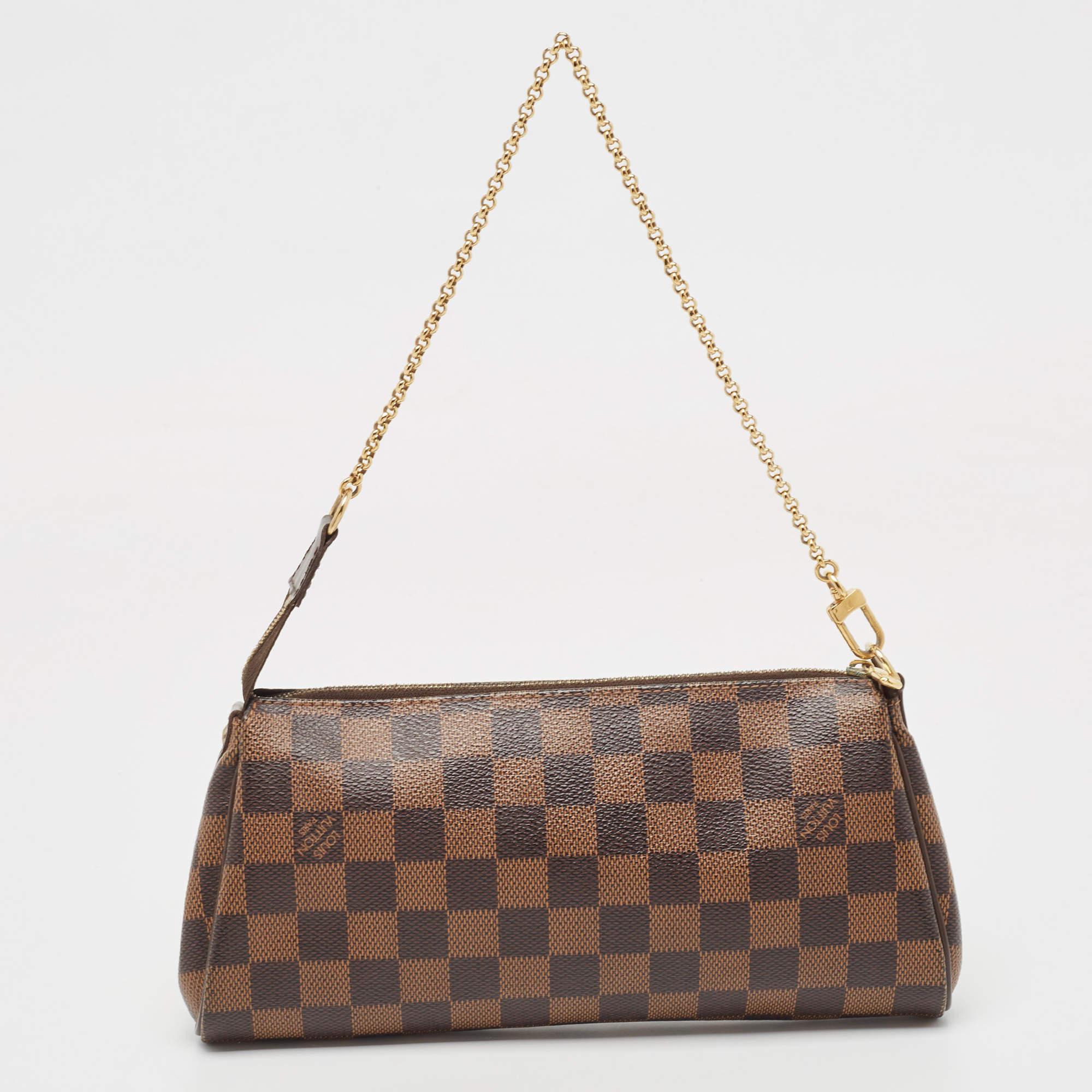Crafted from Damier Ebene canvas, this Eva Pochette bag is a creation by Louis Vuitton. The bag features a well-sized canvas interior that is secured by a gold-tone zipper. It comes with a chain and a leather strap.


