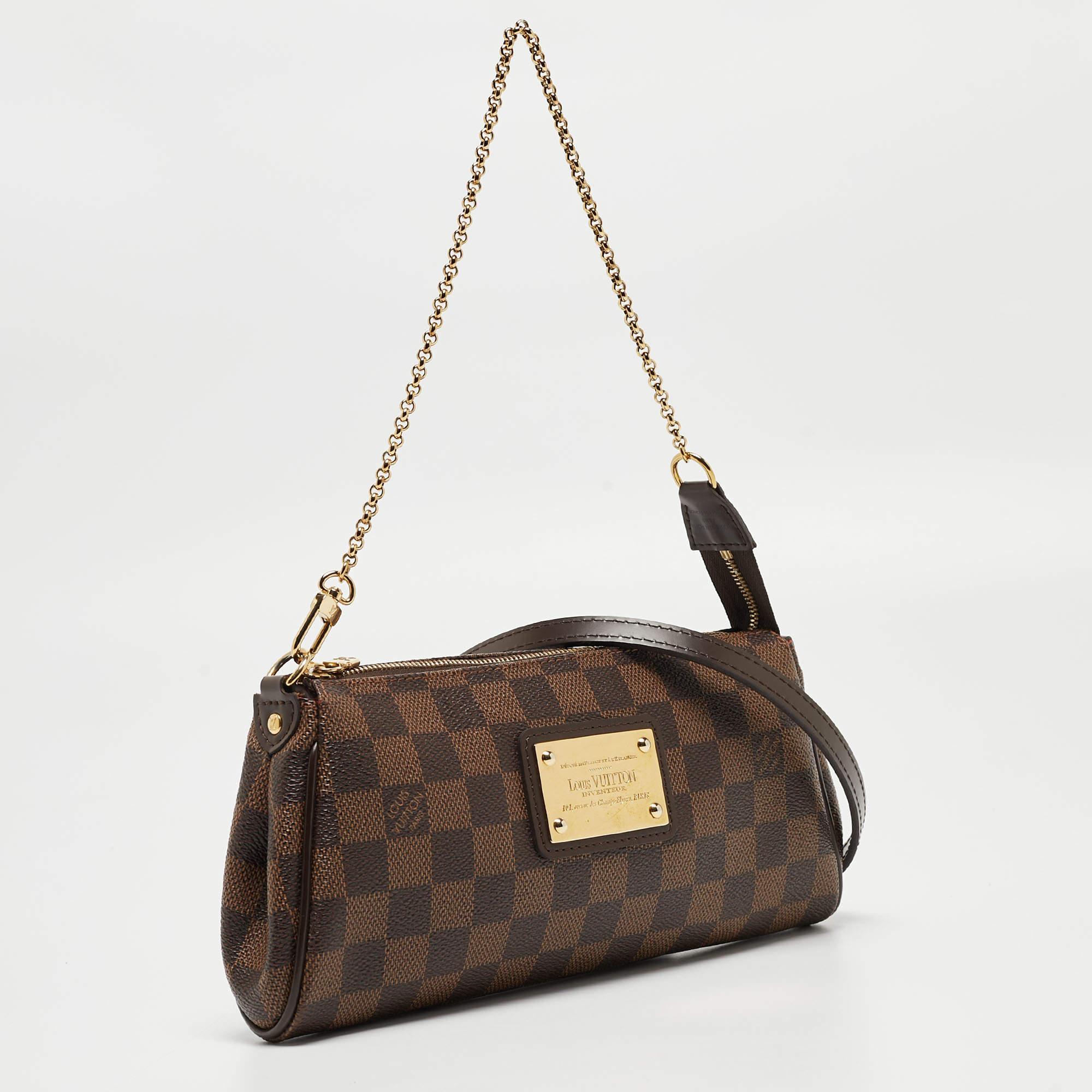 Crafted from Damier Ebene canvas, this Eva Pochette bag is a creation by Louis Vuitton. The bag features a well-sized canvas interior that is secured by a gold-tone zipper. It comes with a chain and a leather strap.

