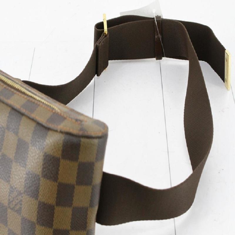 Brown Damier Ebene coated canvas Louis Vuitton Geronimos waist bag with gold-tone hardware, single adjustable waist strap with buckle closure, single pocket at exterior with snap closure, red canvas lining and zip around