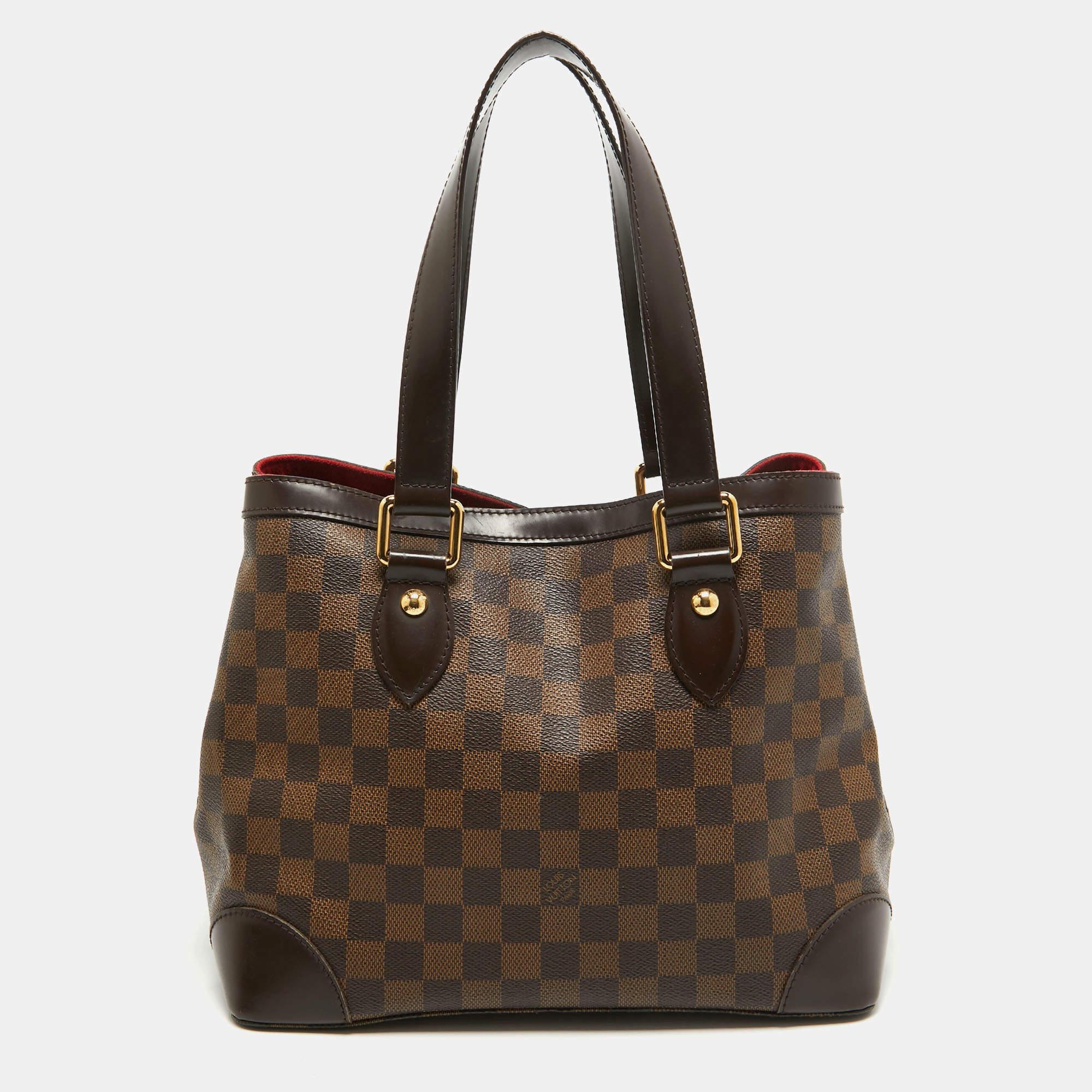 Louis Vuitton a créé le motif de la toile Damier en 1888, qui est devenu depuis la marque de fabrique de la marque. Nommé d'après la banlieue de Londres, ce sac fourre-tout Hampstead PM est doté de poignées supérieures en cuir et de ferrures