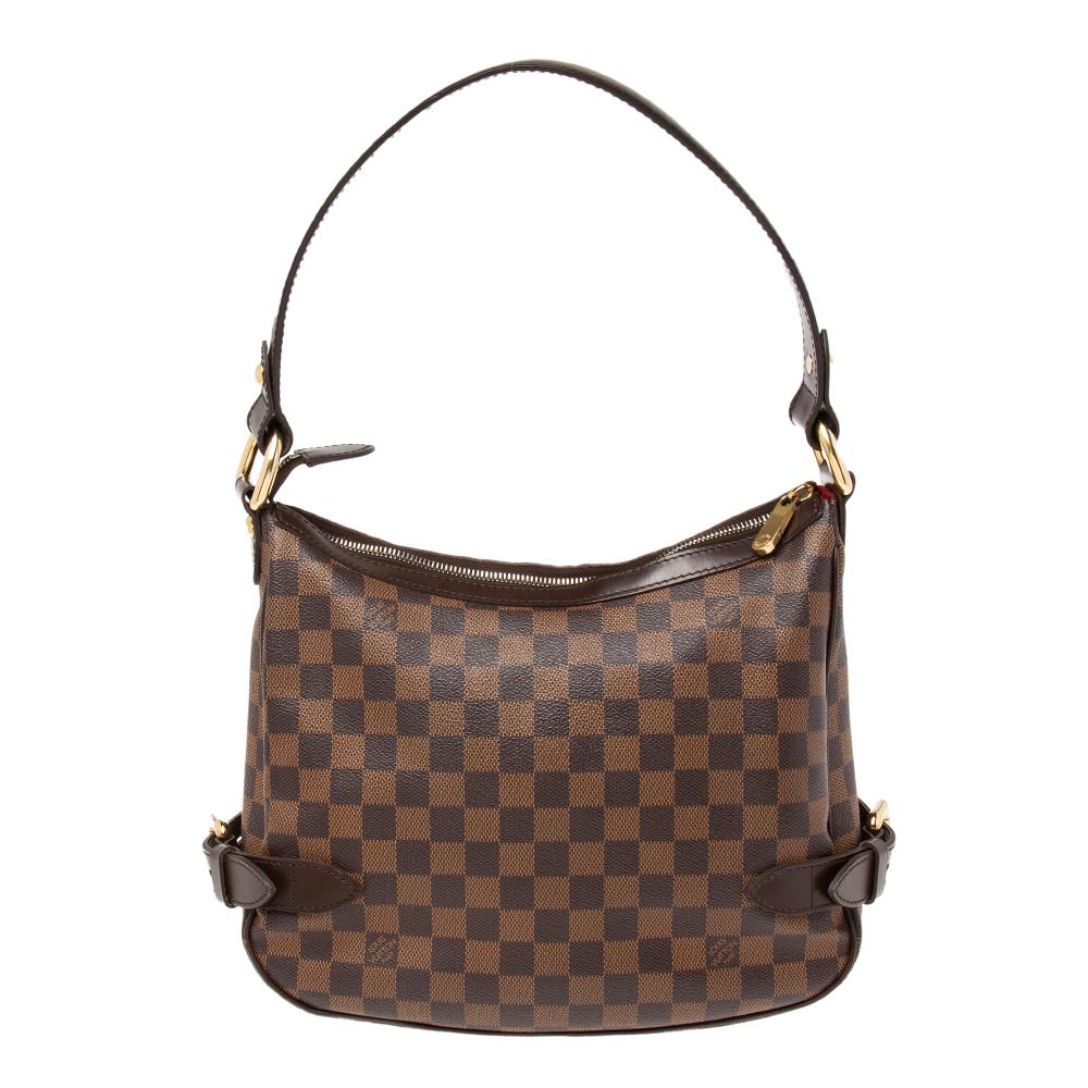 This gorgeous Louis Vuitton bag has been crafted out of Damier Ebene canvas. It features a single leather handle, a buckled front flap, and a roomy Alcantara-lined interior. This Highbury bag is a fine accessory to accompany your daily