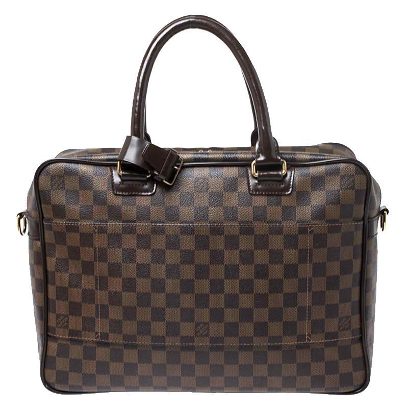 Smart and stylish, this Icare bag from Louis Vuitton deserves a special place in your closet! It is crafted from LV's signature Damier Ebene canvas and features dual top handles, a front zip pocket and a top zipper that opens to reveal a capacious