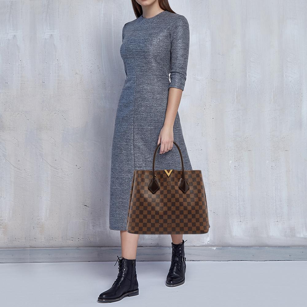 For the woman who is always on the go, Louis Vuitton offers her the Kensington! It is finely made from the brand's signature Damier Ebene canvas and designed as an open-top with a zip compartment dividing the spacious Alcantara interior. It comes