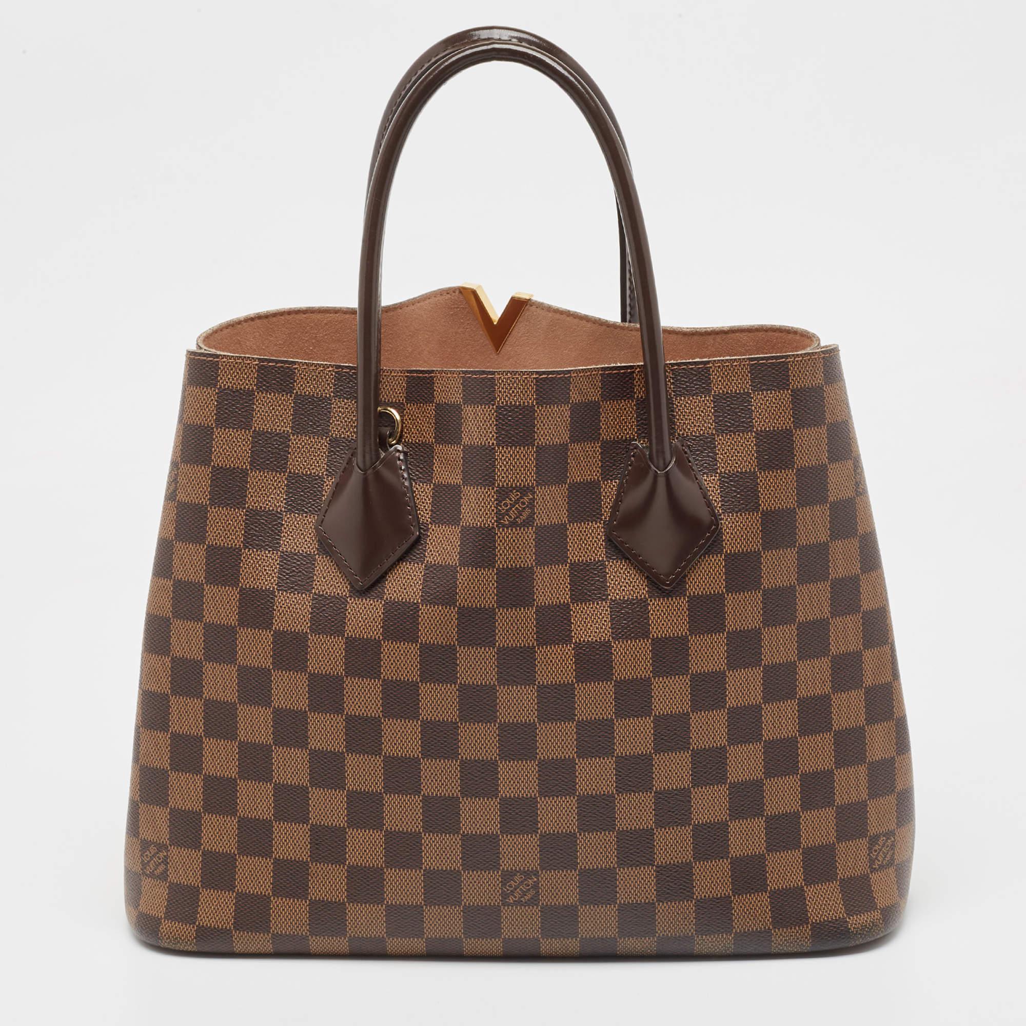 For the woman who is always on the go, Louis Vuitton offers her the Kensington! It is finely made from Damier Ebene canvas and designed as an open top with an Alcantara interior. It comes with two strong handles, protective metal feet, and a