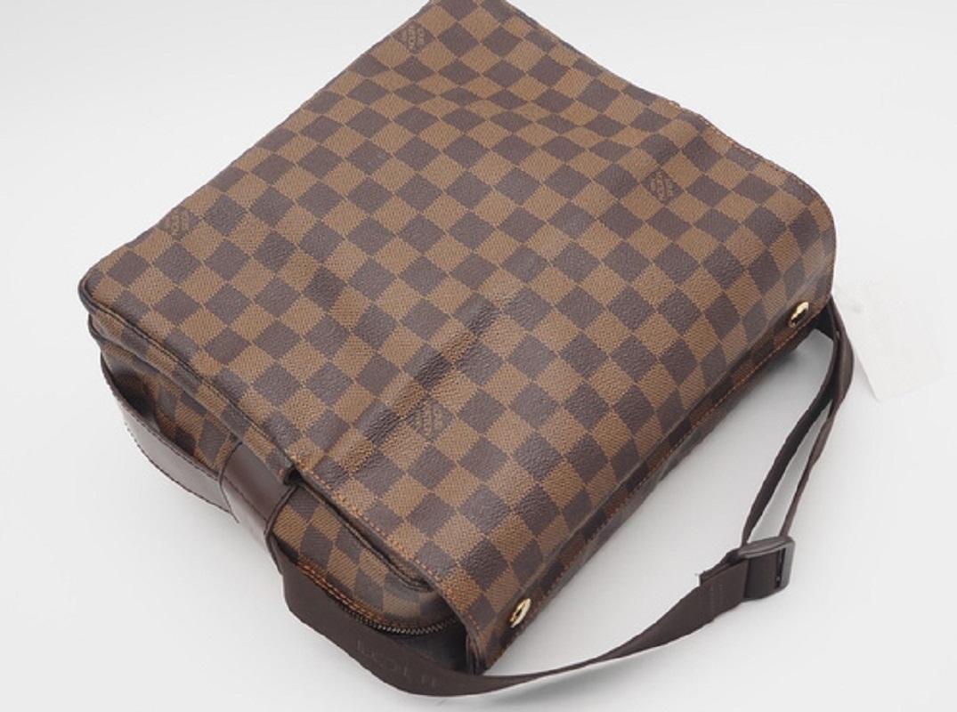 Brown Damier Ebene coated canvas Louis Vuitton Naviglio messenger bag with gold-tone hardware, dark brown leather trim, single adjustable flat shoulder strap, three interior compartments; one with zip closure, brown woven lining, single slip pocket