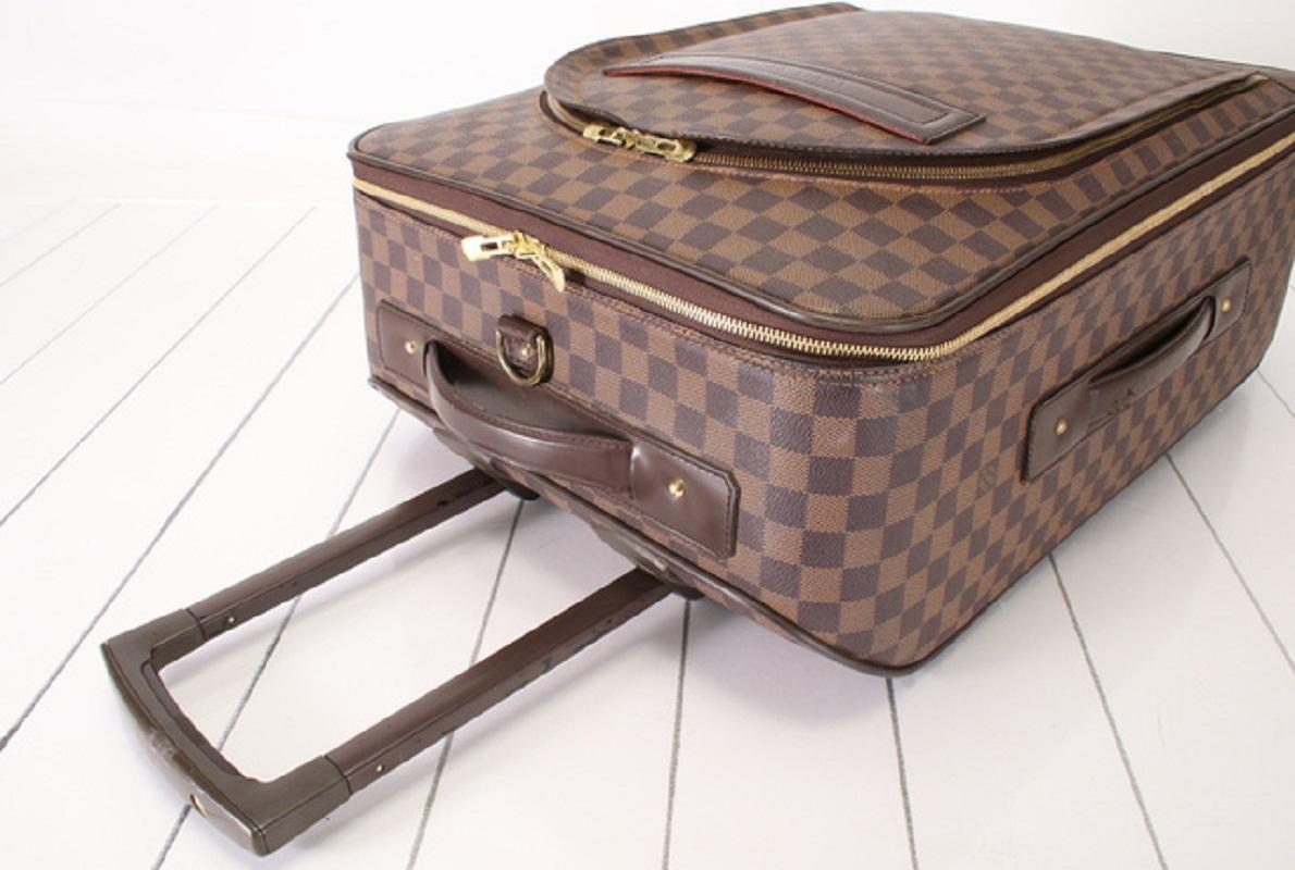 Dark brown and cannelle Damier Ebene coated canvas Louis Vuitton Pegase Business 55 with gold-tone hardware, flat handles at top and side, retractable pull-handle at top, dual exterior pockets; one with concealed zip-around closure, embossed logo at