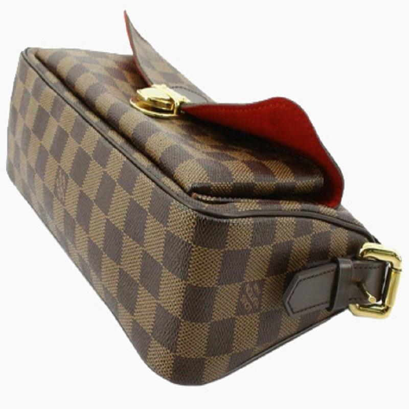 Brown Damier Ebene coated canvas Louis Vuitton Ravello GM bag with gold-tone hardware, dark brown leather trim, single flat shoulder strap, exterior pocket featuring push-lock closure at front, red Alcantara lining, single pocket at interior wall