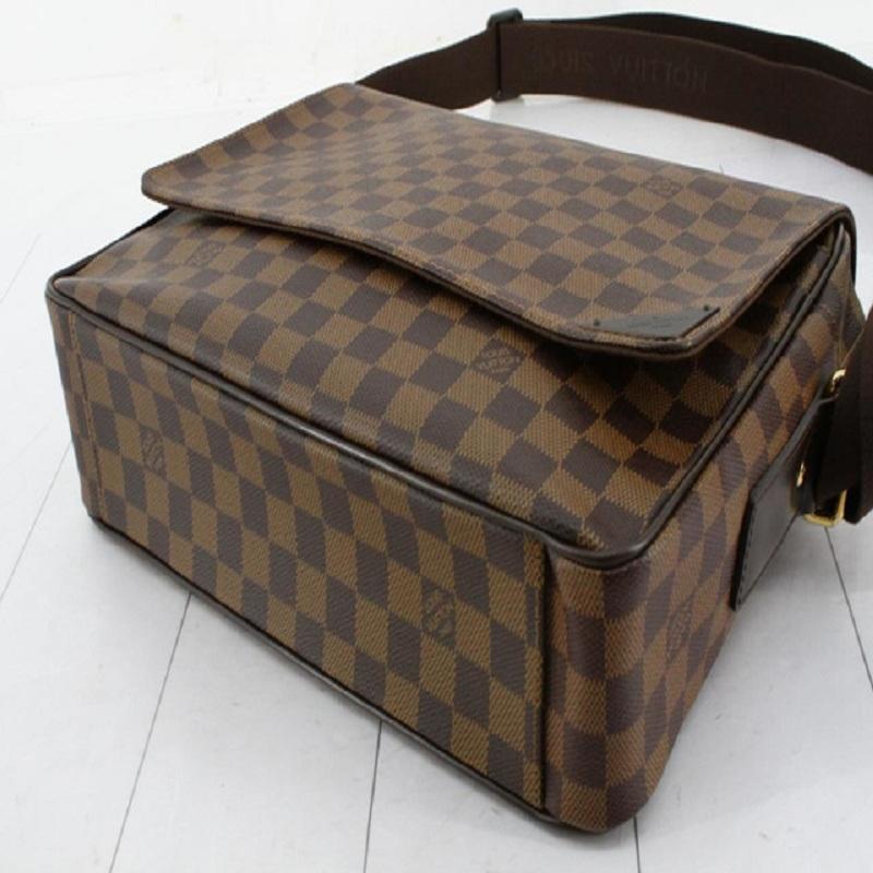 Men's brown and tan Damier Ebene coated canvas Louis Vuitton Shelton MM with gold-tone hardware, single flat woven shoulder strap, single slit pocket at flap underside, brown woven lining, five pockets at interior walls and zip closure at top with
