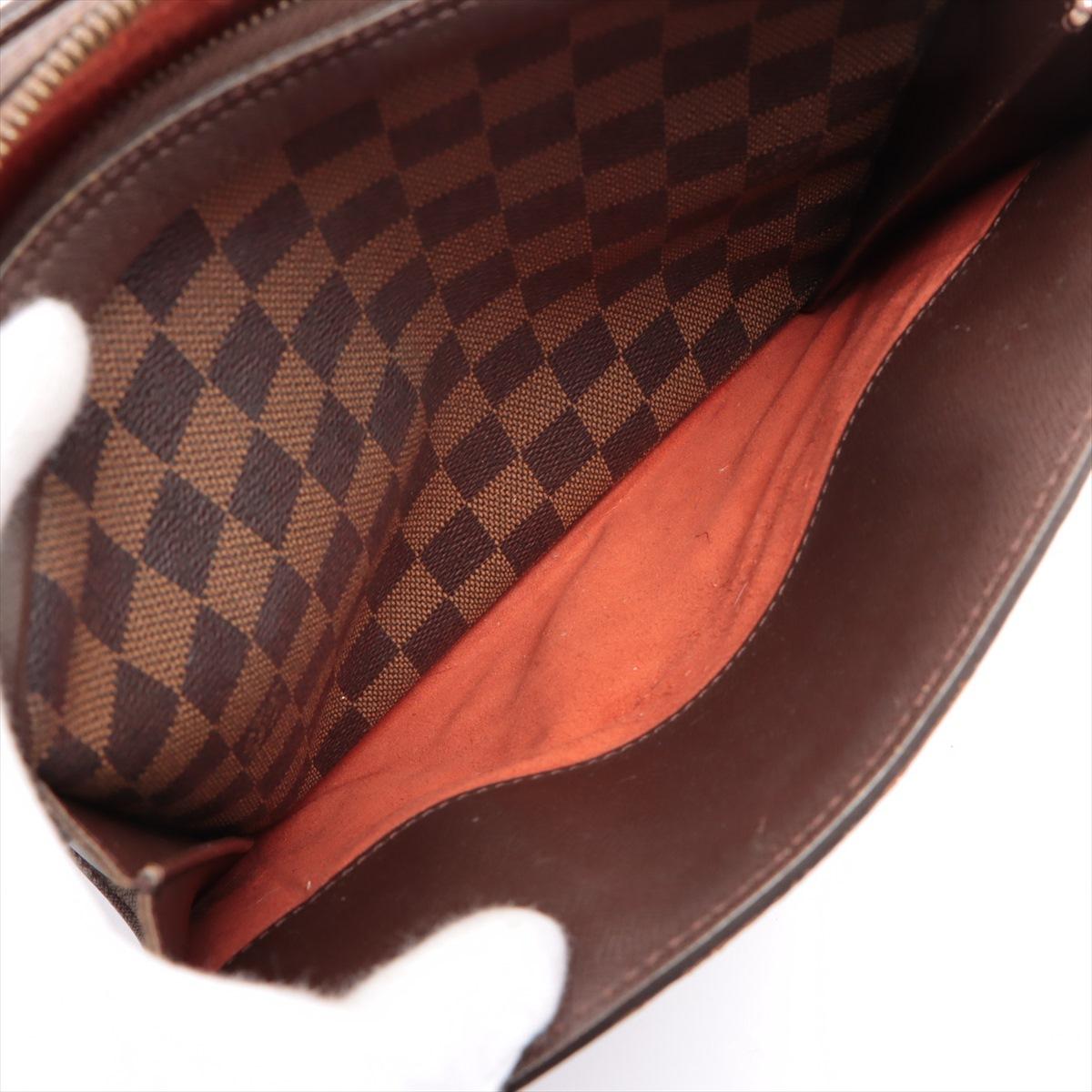 Brown and tobacco Damier Ebene coated canvas Louis Vuitton Triana Handbag with gold-tone hardware, mocha leather trim, dual rolled handles, dual slit pockets at exterior, orange Alcantara lining, single zipped pocket at interior wall and zip closure