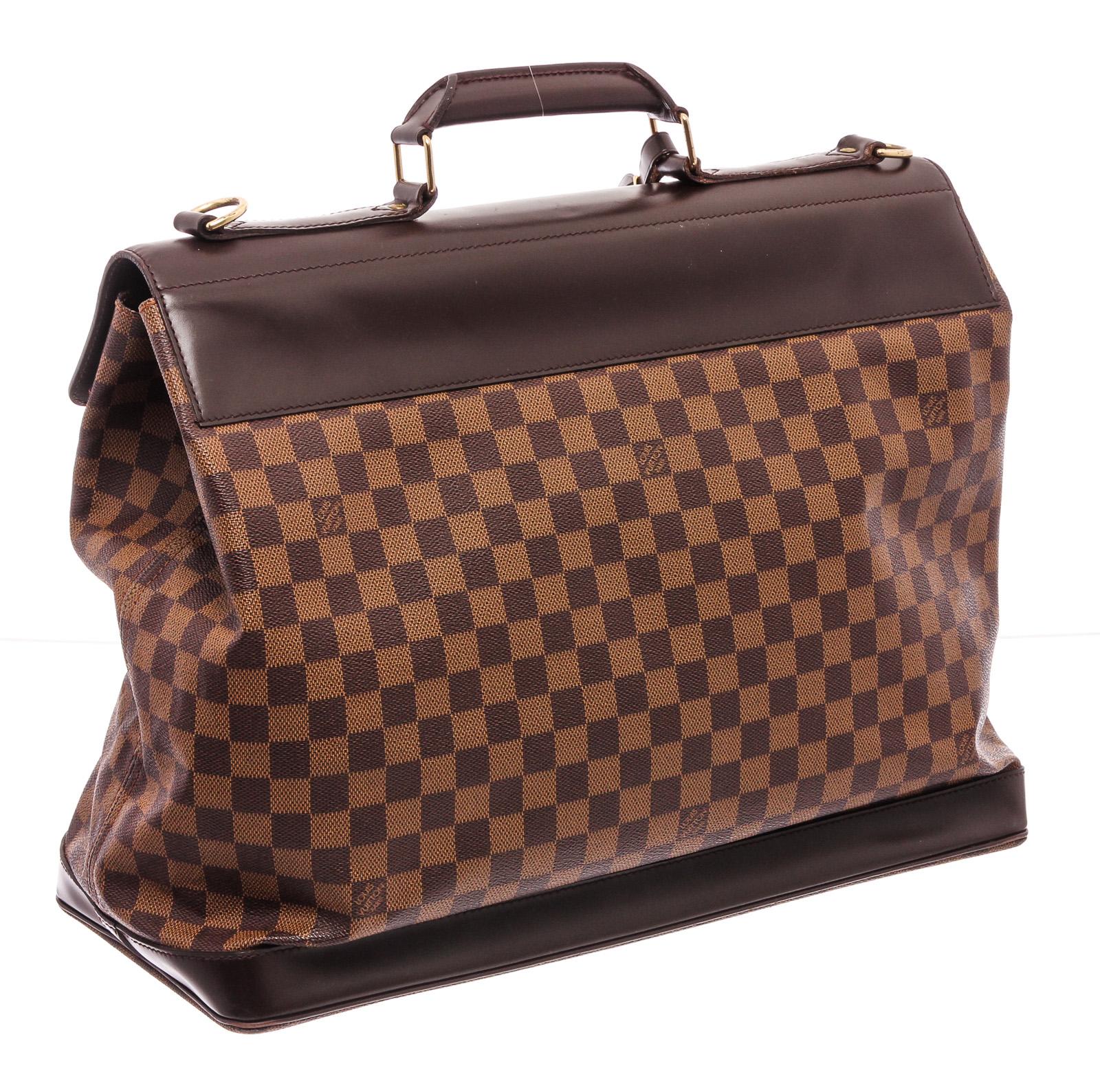 Damier Ebene coated canvas Louis Vuitton West End PM with brass hardware, single rolled top handle, optional flat shoulder strap, moka leather trim, terracotta canvas lining, single zip pocket at interior and dual buckle closures at front.

22117MSC