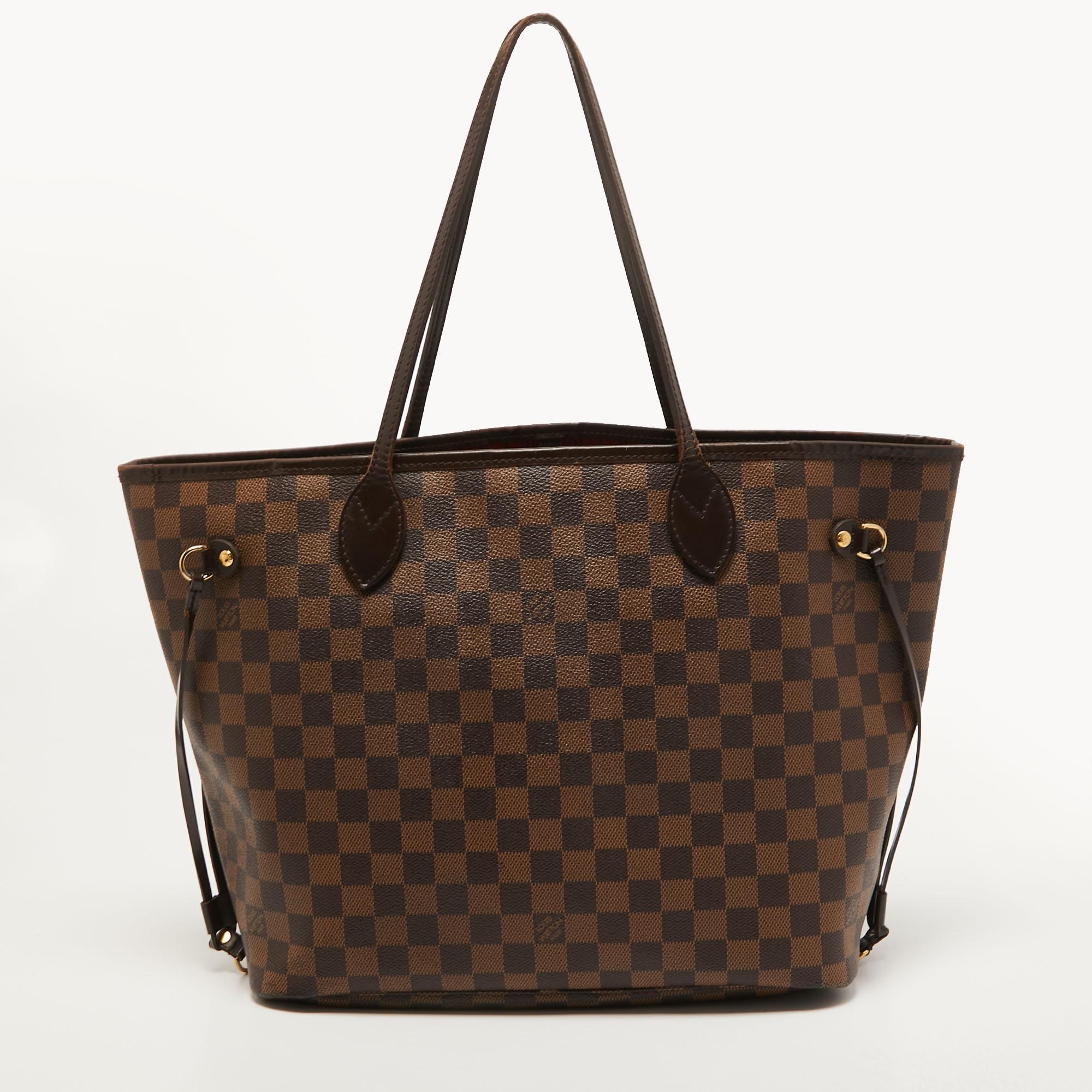 Introduced in 2007, the Neverfull by Louis Vuitton is applauded for its innovative design and faultless craftsmanship. This MM bag comes crafted from Damier Ebene canvas, and its classy features contribute to its timeless elegance. It is held at the