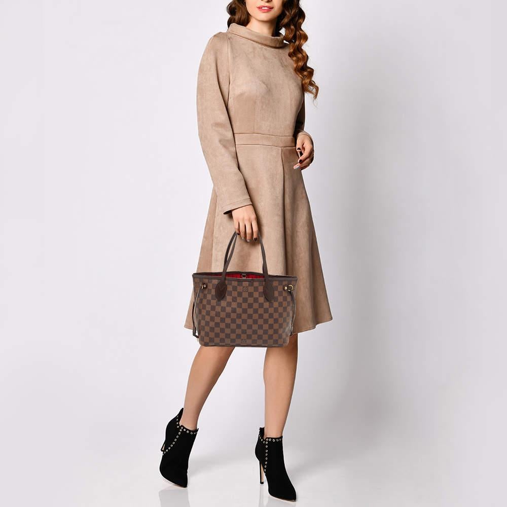Louis Vuitton's Neverfull was first introduced in 2007 and even today it is a popular design. Crafted from Damier Ebene canvas and leather this Neverfull is gorgeous. The bag has drawstrings on the sides a spacious canvas interior that can house all