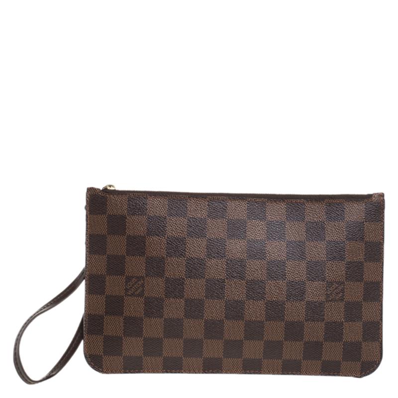 The exclusive Neverfull pochette from the house of Louis Vuitton is a stylish way to carry your basics. The pochette is crafted from the signature Damier Ebene canvas body that imparts grace, while the gold-tone top zip closure adds the perfect