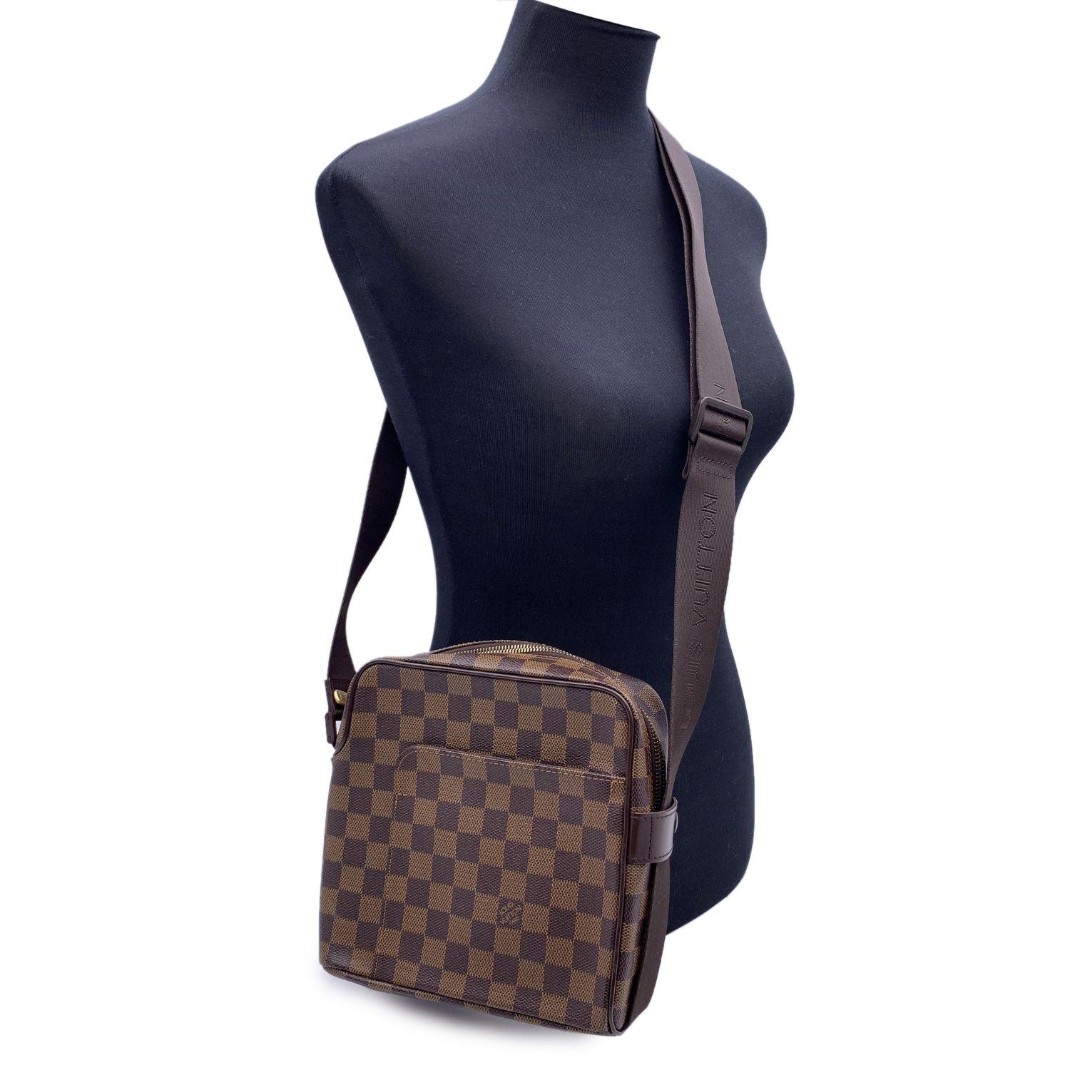 Louis Vuitton Olav PM Messenger Bag. Perfect for the style man or woman. Damier canvas. Double zipper opening. Interior mobile phone pocket. Brown textile lining. Matte brown metallic pieces. Adjustable shoulder strap embroidered with the LOUIS