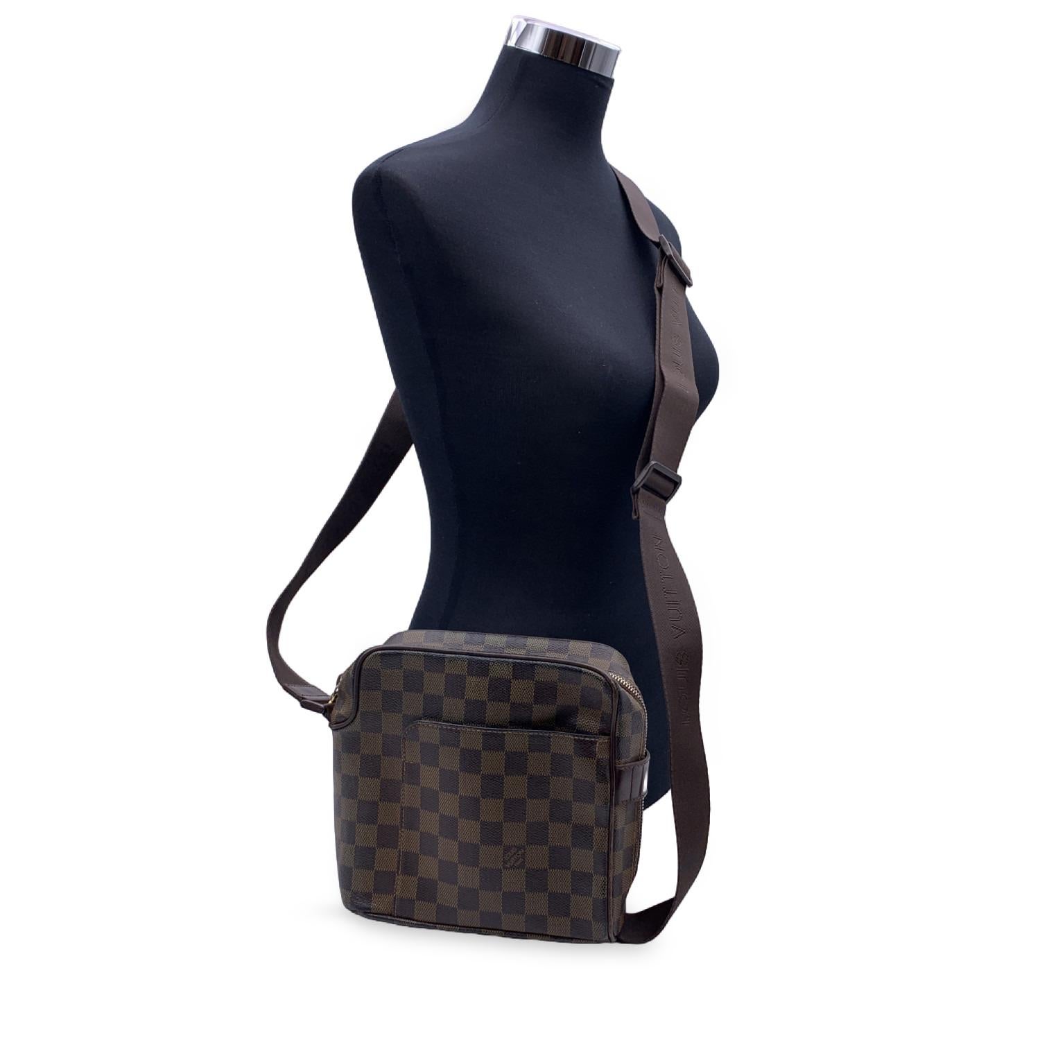 Louis Vuitton Olav PM Messenger Bag. Perfect for the style man or woman. Damier canvas. Double zipper opening. Interior mobile phone pocket. Brown textile lining. Matte brown metallic pieces. Adjustable shoulder strap embroidered with the LOUIS
