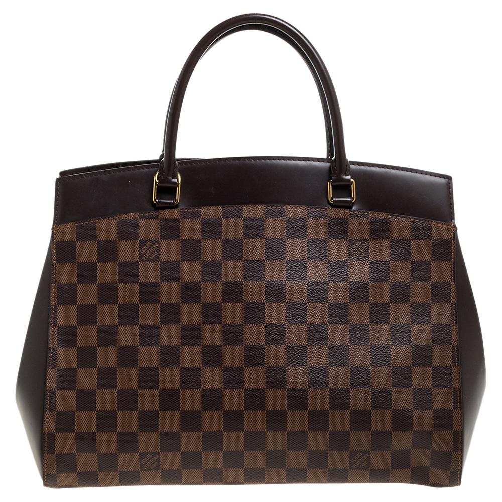 The Rivoli by Louis Vuitton has an undeniably appealing shape. This one in MM is crafted from Damier Ebene canvas. It has a sturdy structure and the design involves a twist lock on the front, two handles, and a spacious Alcantara interior. The bag